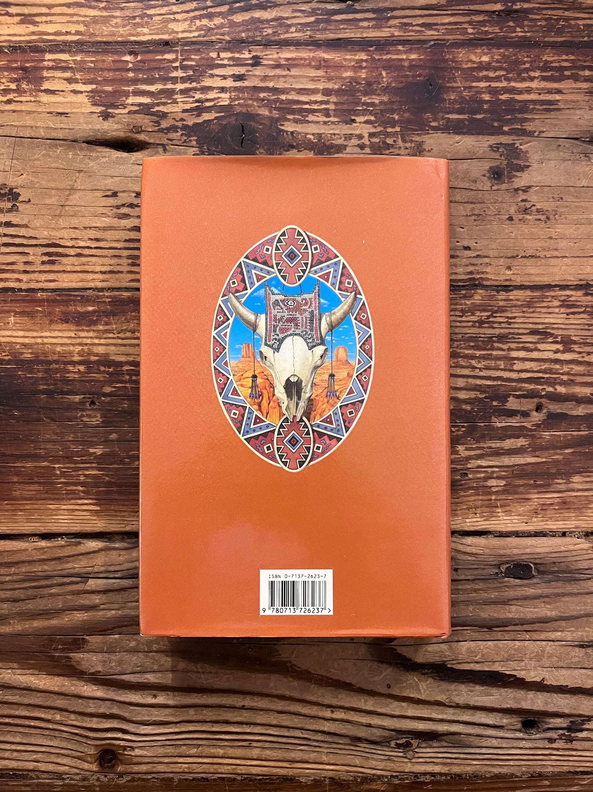 Back cover of book titled 'Native American Myth & Legend' by Mike Dixon-Kennedy on a wooden surface