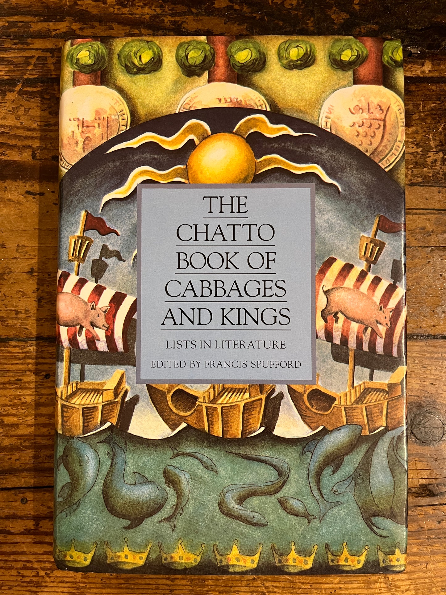 cover of the book "he Chatto book of cabbages and kings" on a wooden background