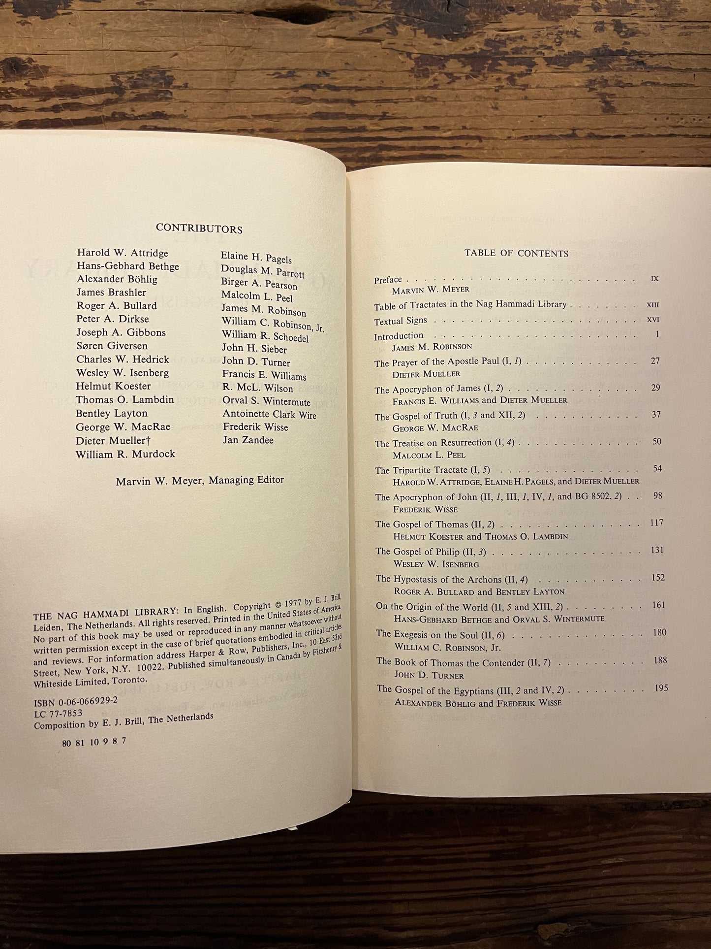 Open book titled 'The Nag Hammadi Library in English' on a wooden surface