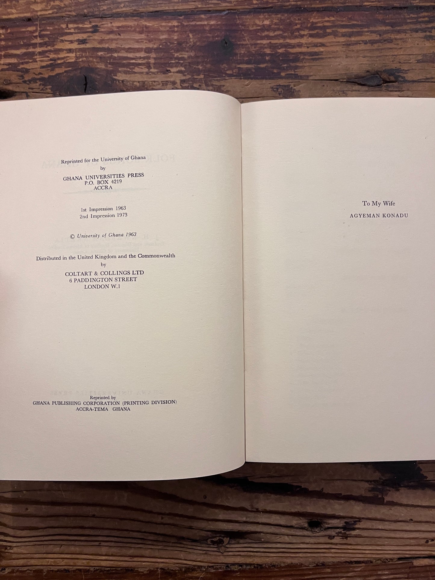 Open book titled 'Folk Songs of Ghana' by J.H. Kwabena Nketia on a wooden surface 