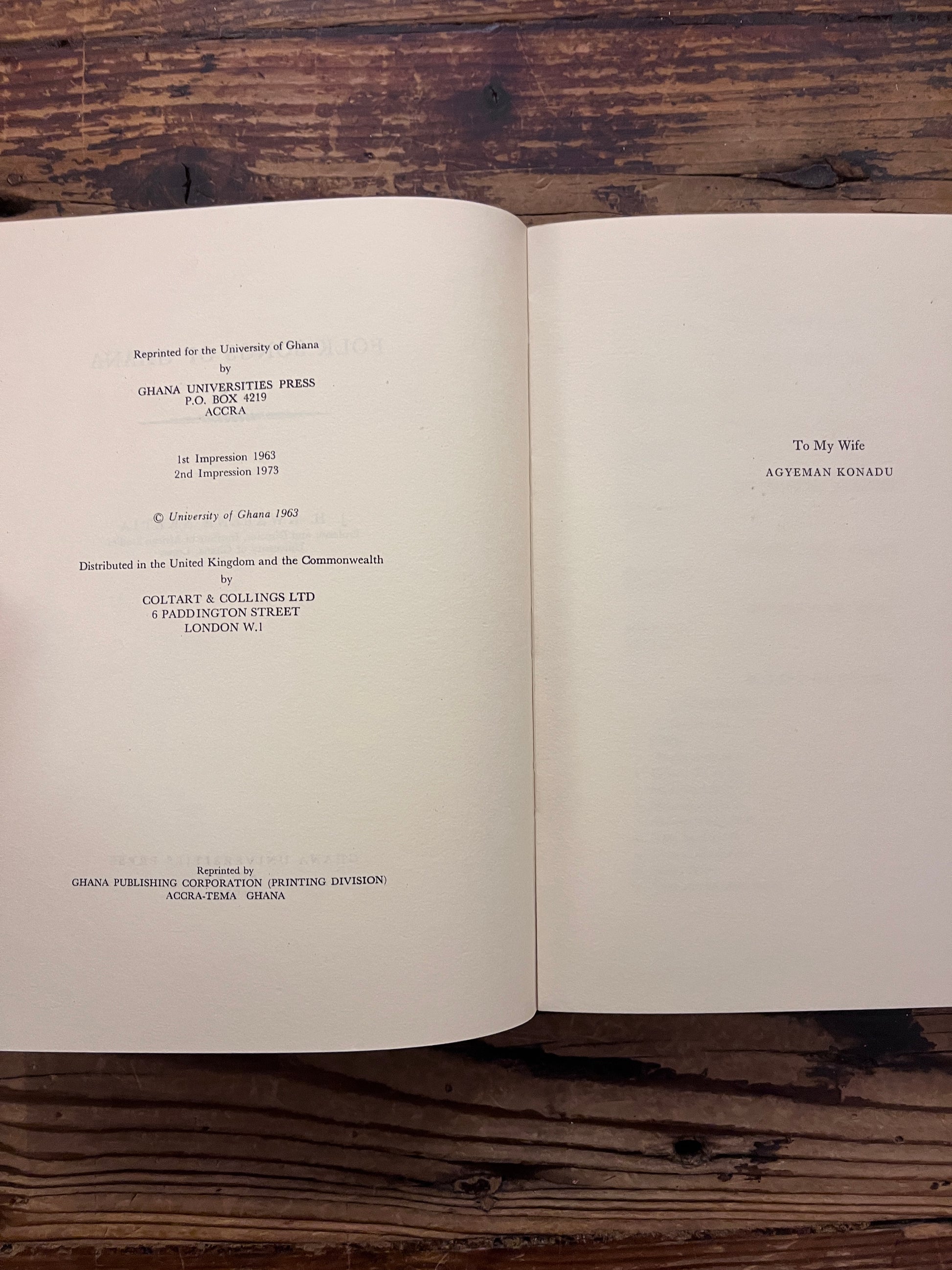 Open book titled 'Folk Songs of Ghana' by J.H. Kwabena Nketia on a wooden surface 