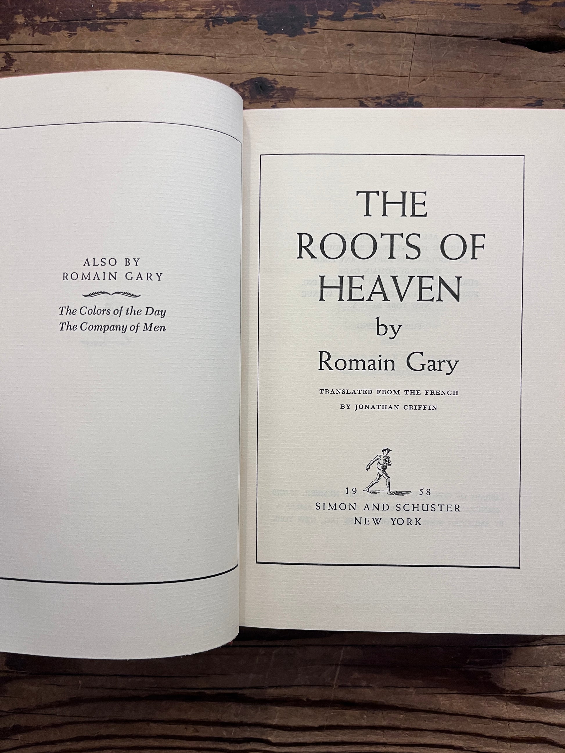 Open book titled 'The Roots of Heaven' by Romain Gary on a wooden surface