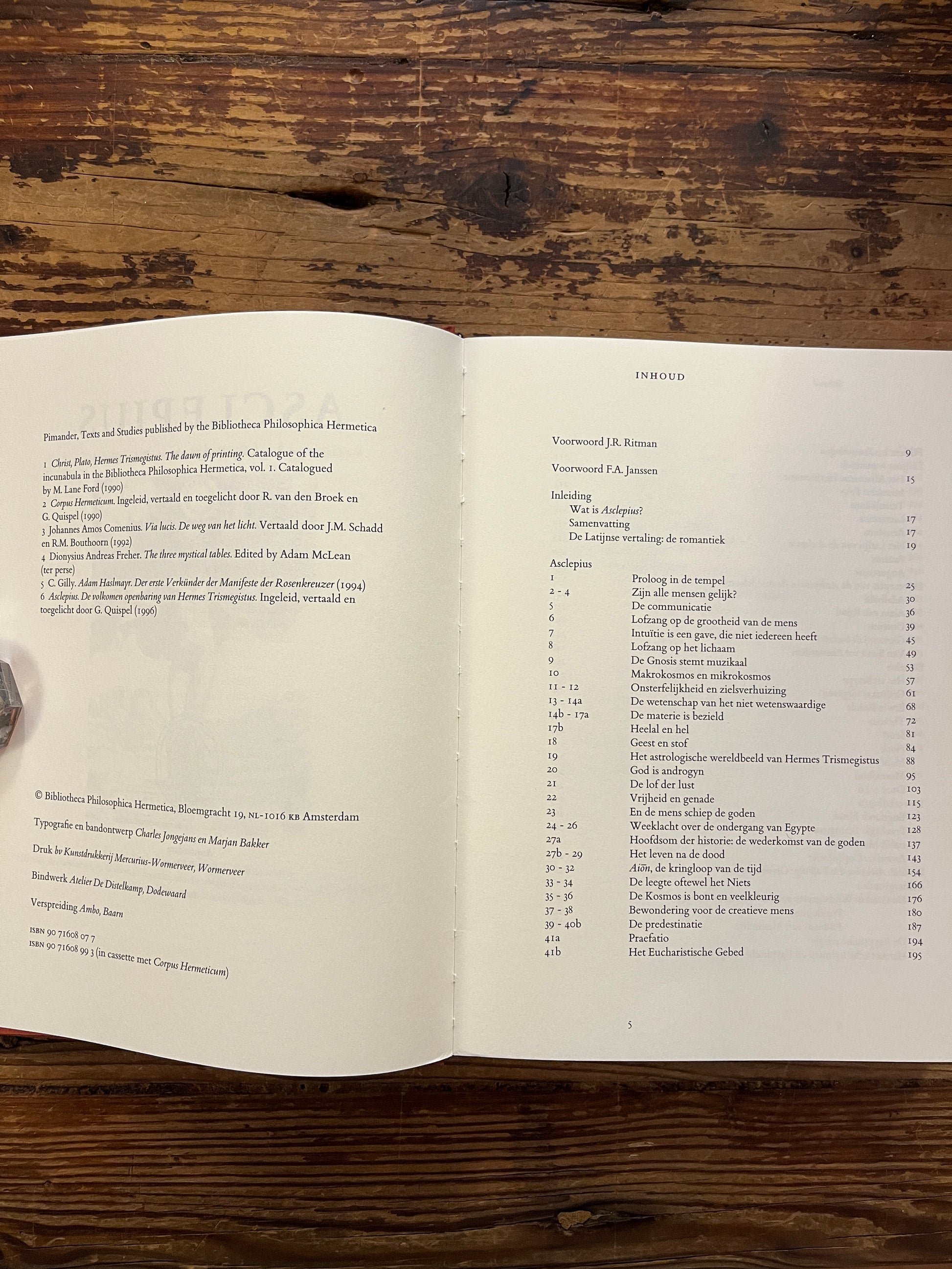 Open boek met de titel 'Asclepius' ingeleid, vertaald en toegelicht door G. Quispel op een houten achtergrond 