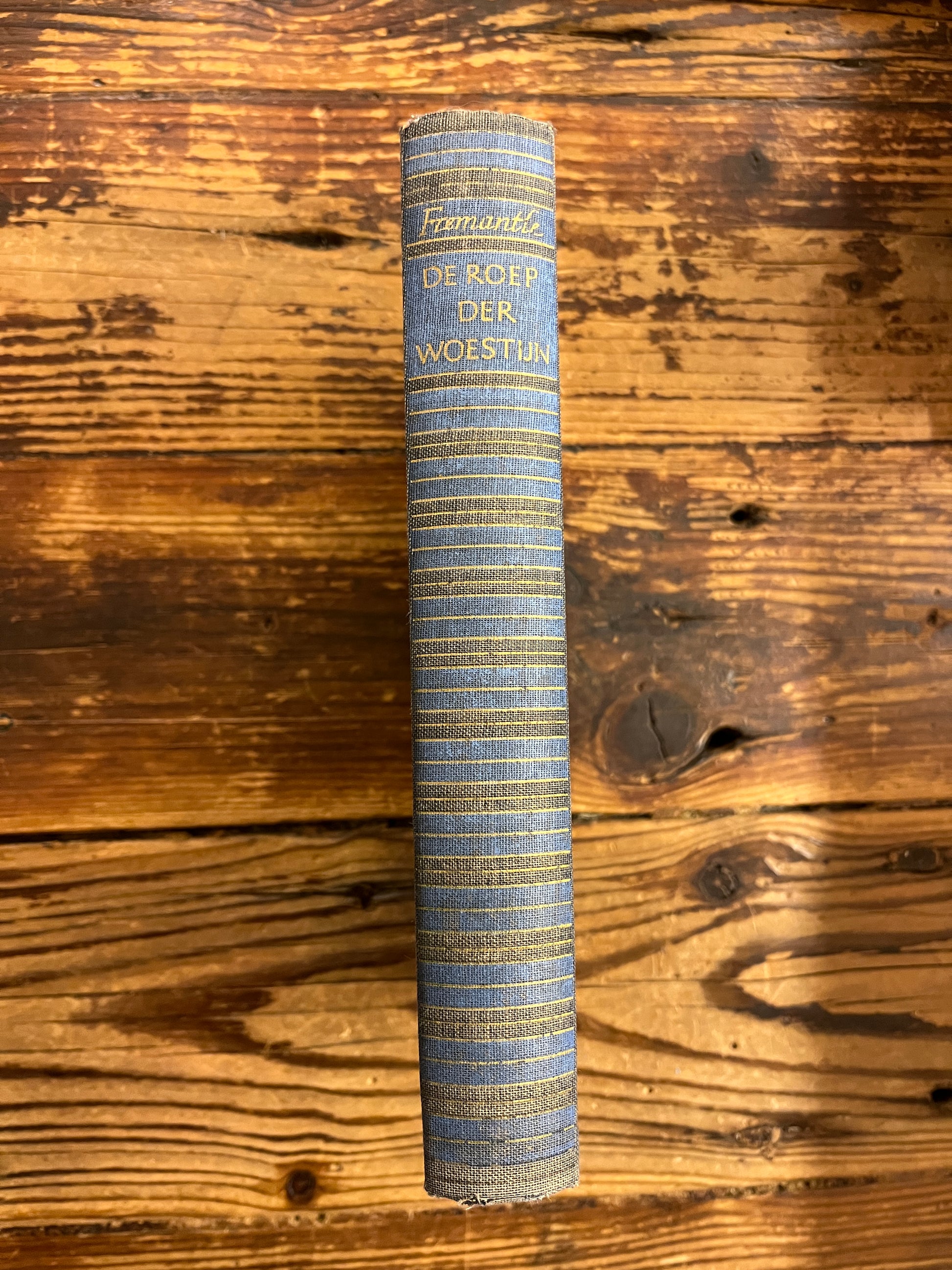 Rug van boek met de titel 'de roep der woestijn' op een houten achtergrond 