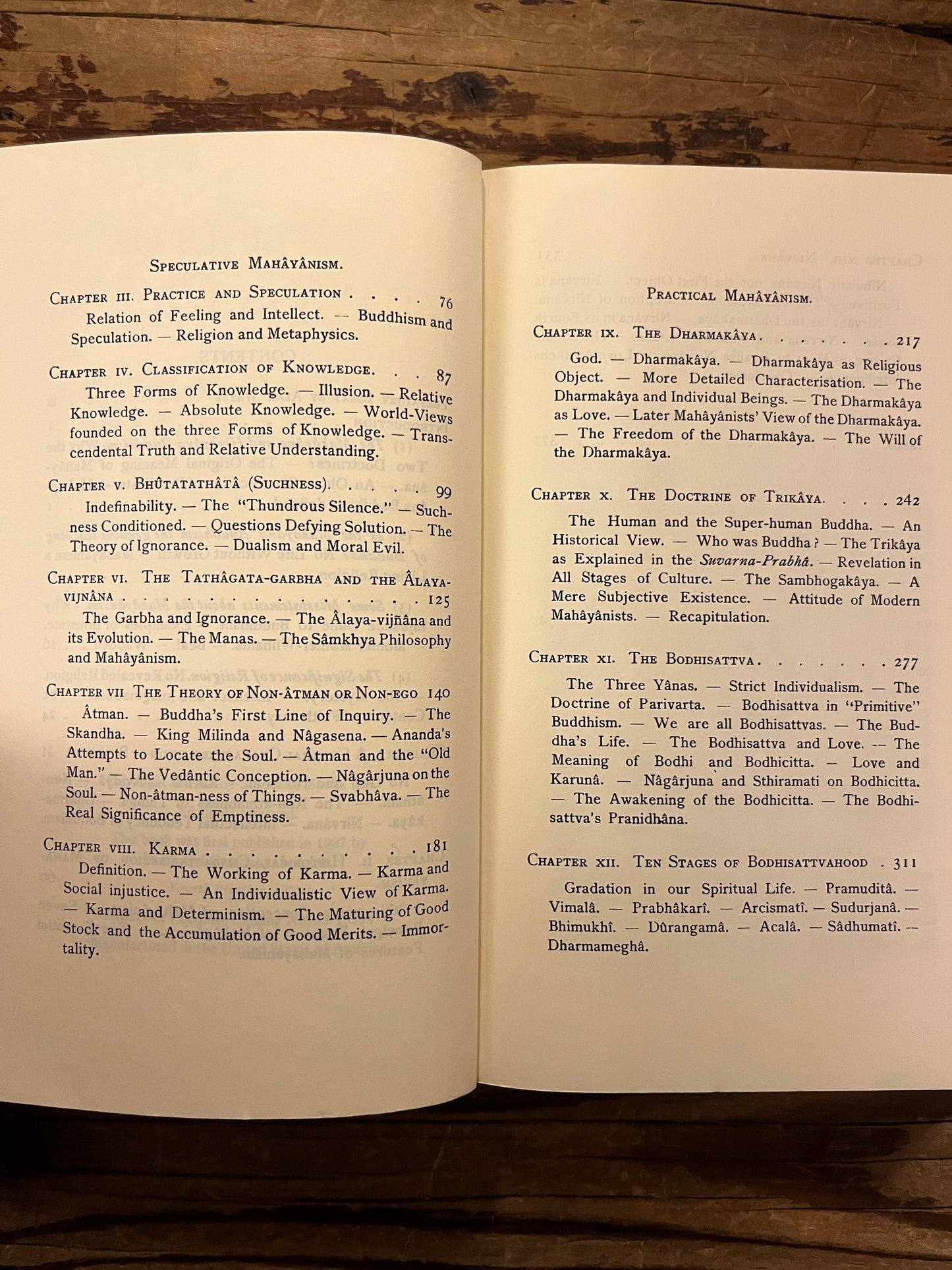 Open book cover of 'Outlines of Mahayana Buddhism' by D.T. Suzuki on a wooden surface