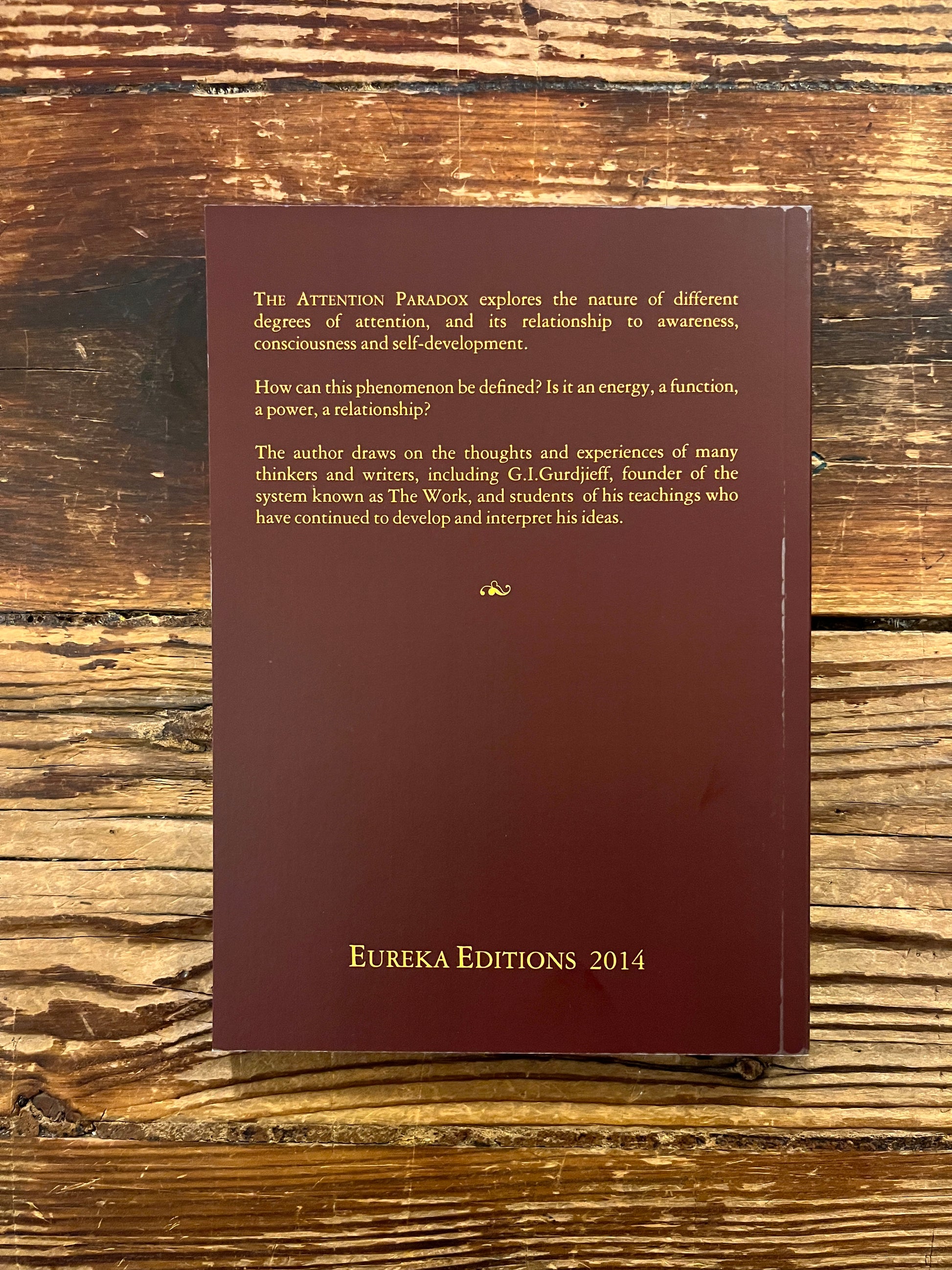 Back cover of book titled 'The Attention Paradox' by Bob Hunter on a wooden surface