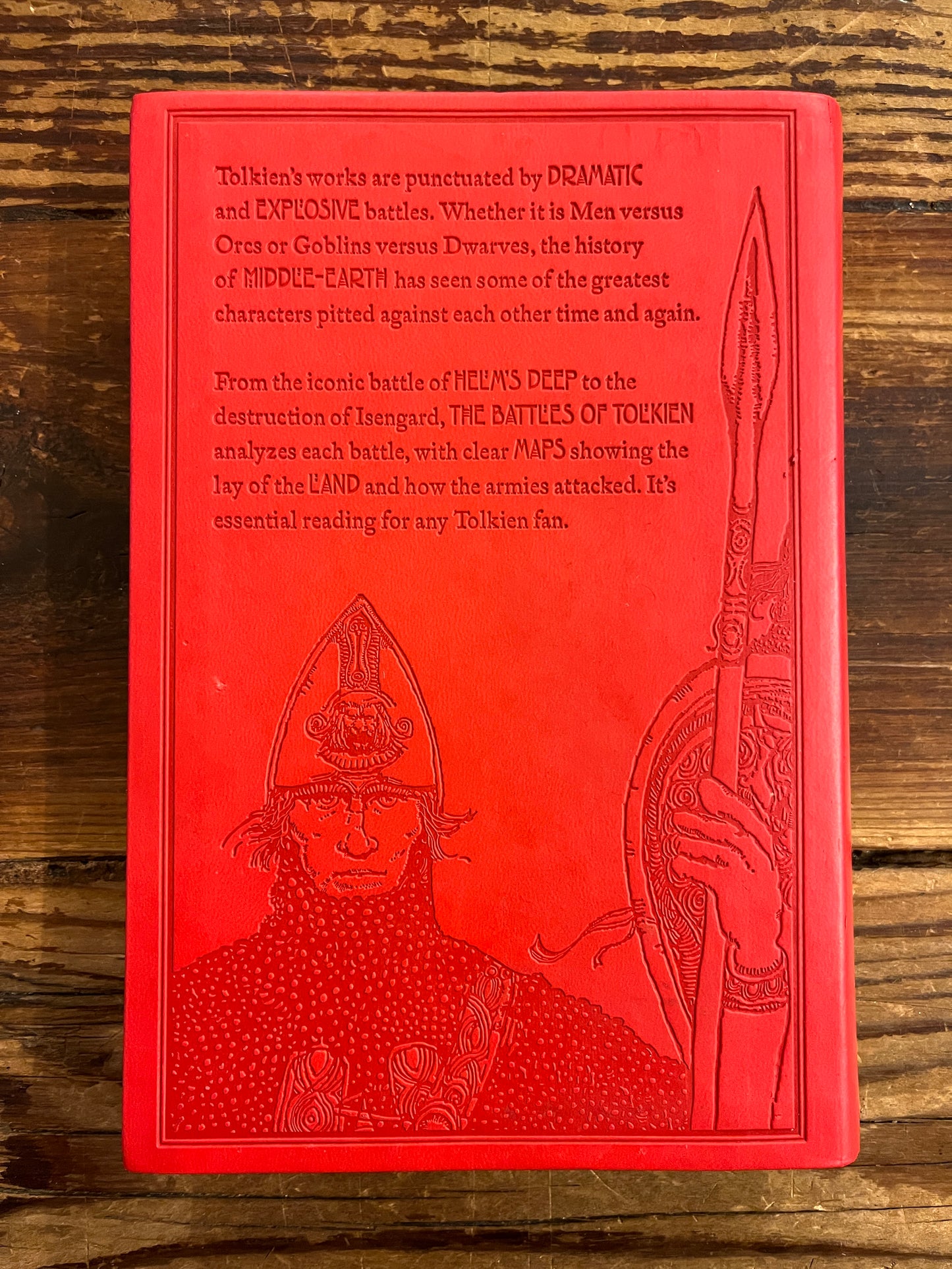 Back cover of book titled 'The Battles of Tolkien' by David Day on a wooden surface