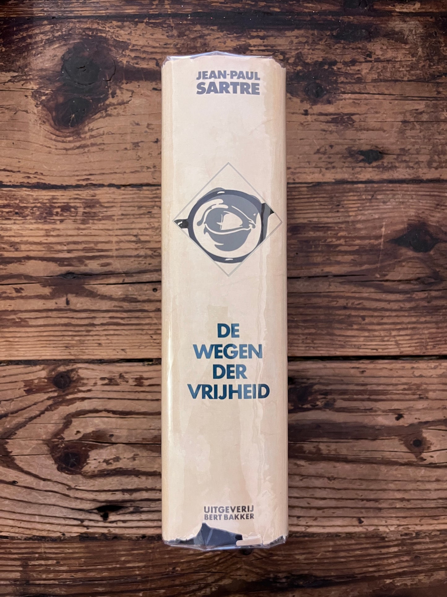 foto van de rug van het boek "de wegen der vrijheid" op houten achtergrond