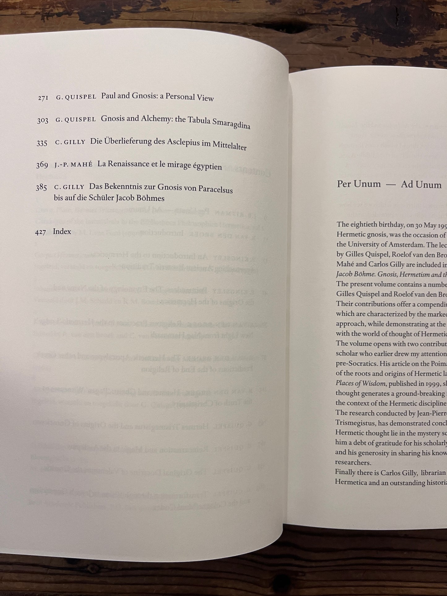 Open book titled 'From Poimandres to Jacob Böhme: Gnosis, Hermetism, and the Christian tradition Edited by Roelof van den Broek and Cis van Heertum' On a wooden surface