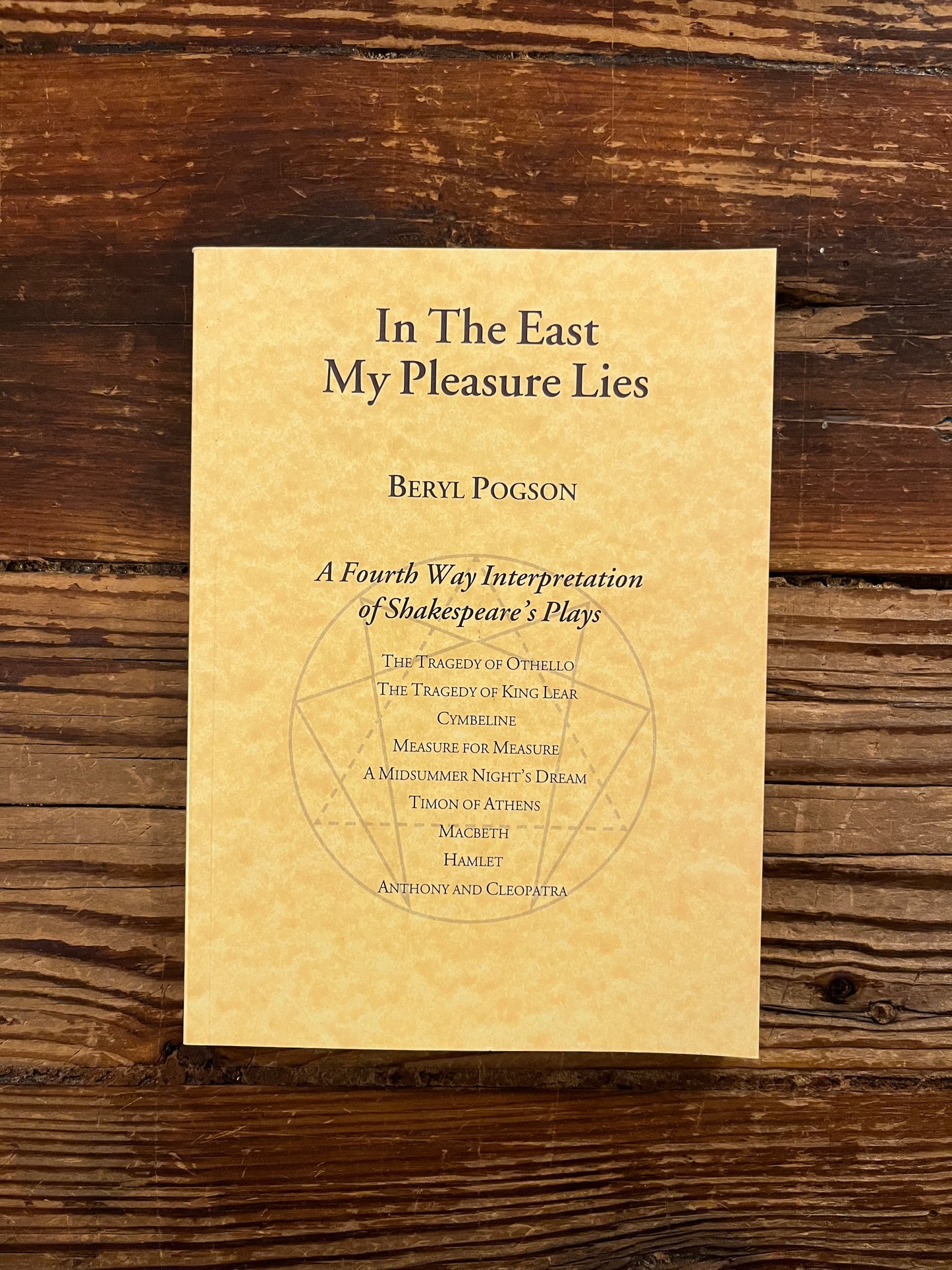 Book titled 'In The East My Pleasure Lies' by Beryl Pogson on a wooden surface