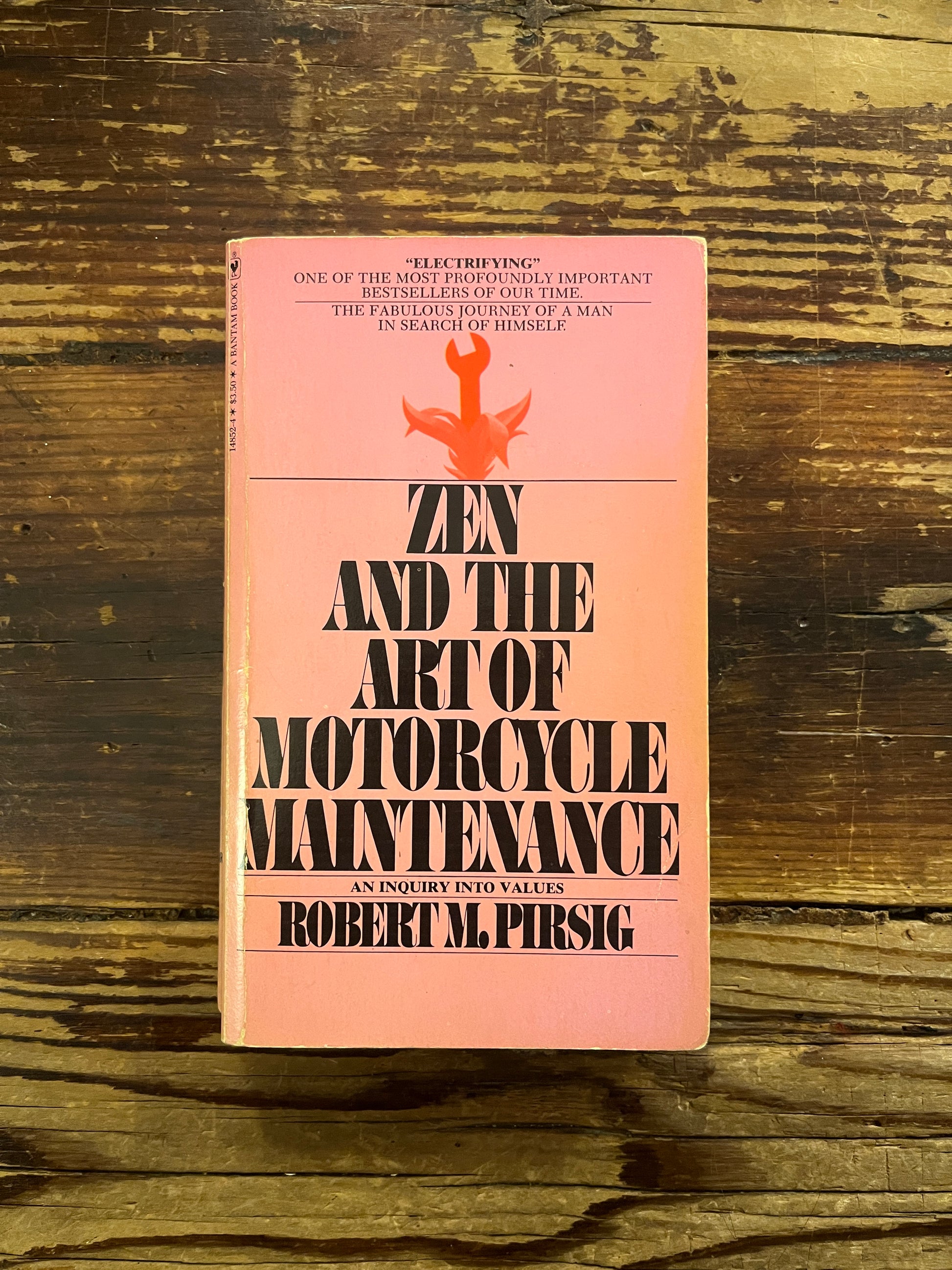 Book titled 'Zen and the Art of Motorcycle maintenance' by Robert M. Persig on a wooden surface