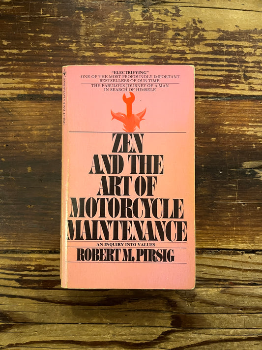 Book titled 'Zen and the Art of Motorcycle maintenance' by Robert M. Persig on a wooden surface