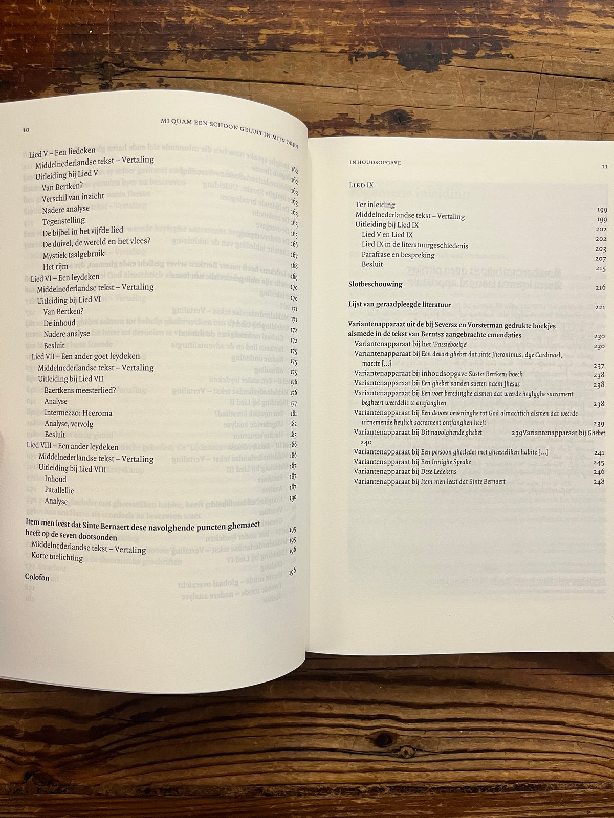 Open boek met de titel 'het werk van Suster Bertken' op een houten achtergrond