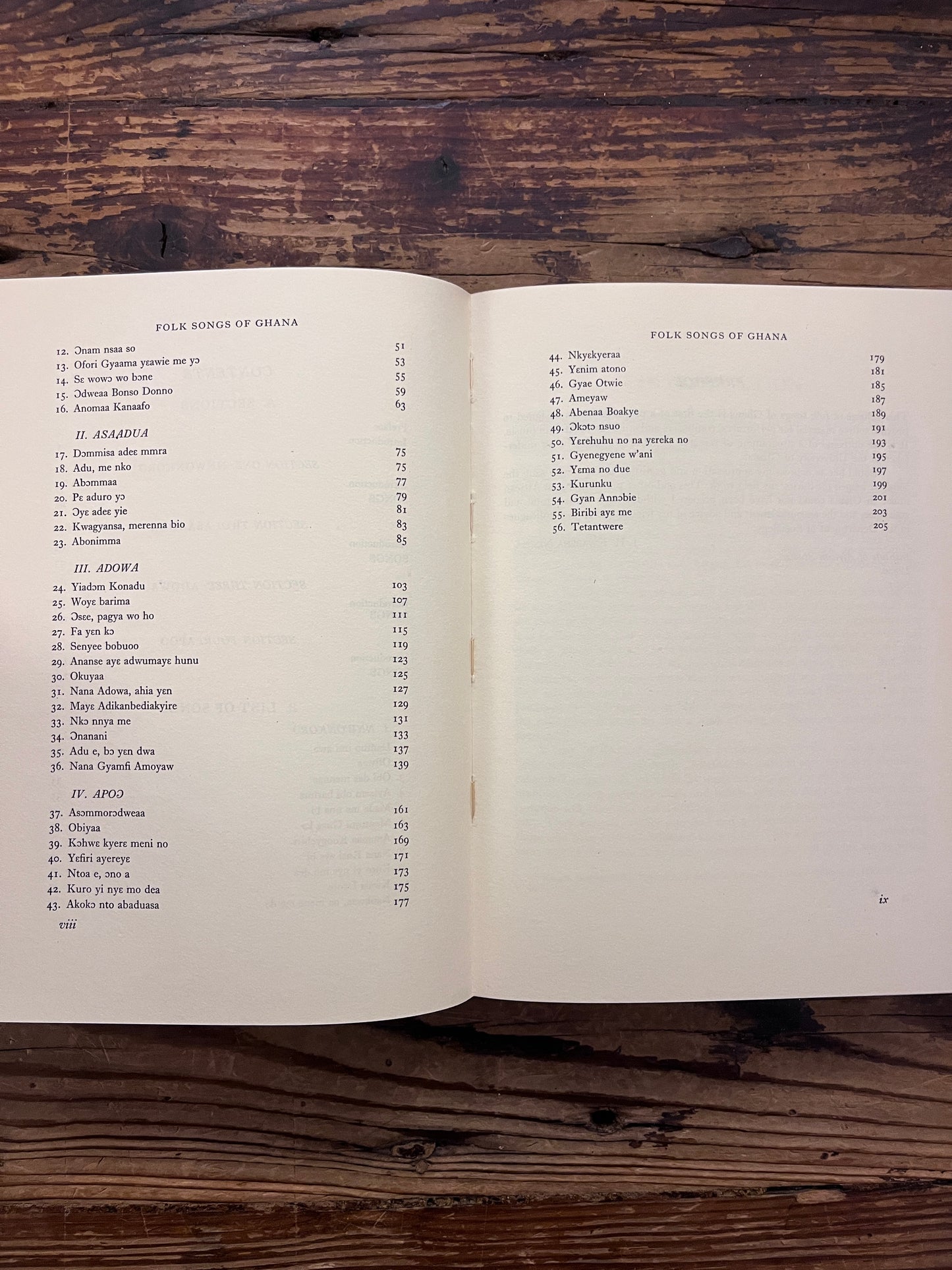 Contents of book titled 'Folk Songs of Ghana' by J.H. Kwabena Nketia on a wooden surface 