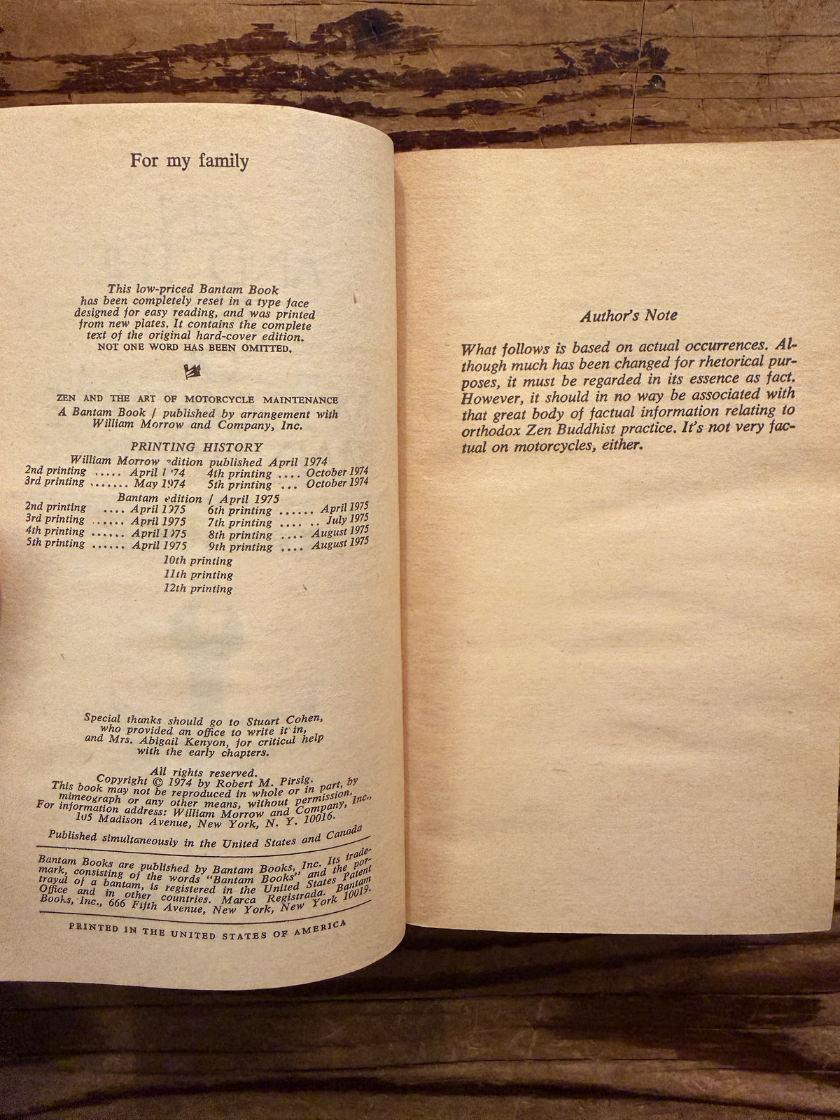 Open book titled 'Zen and the Art of Motorcycle Maintenance' by Robert M. Pirsig on a wooden surface