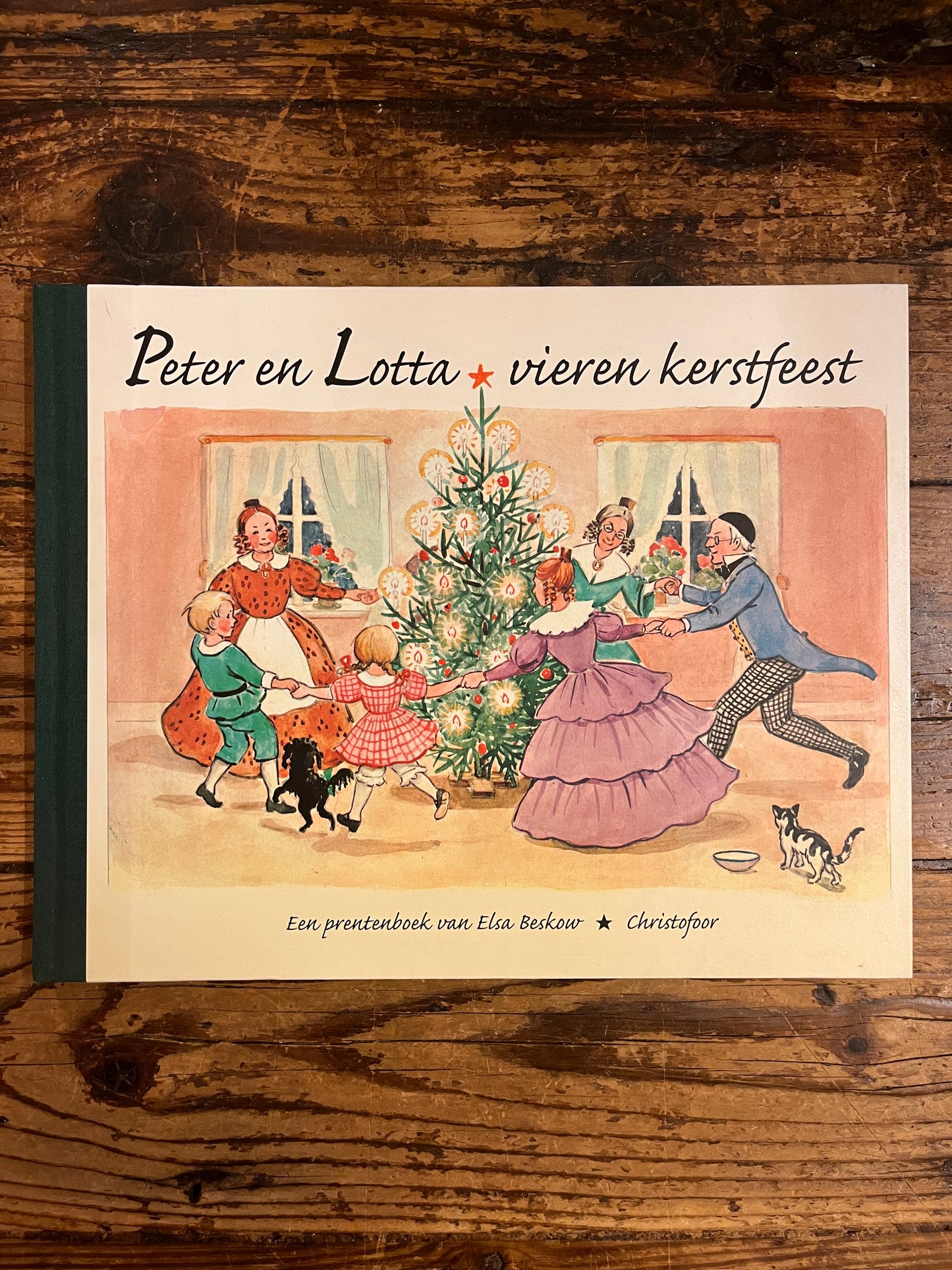 boekomslag van het boek "Peter en Lotta vieren kerstfeest" op een houten achtergrond