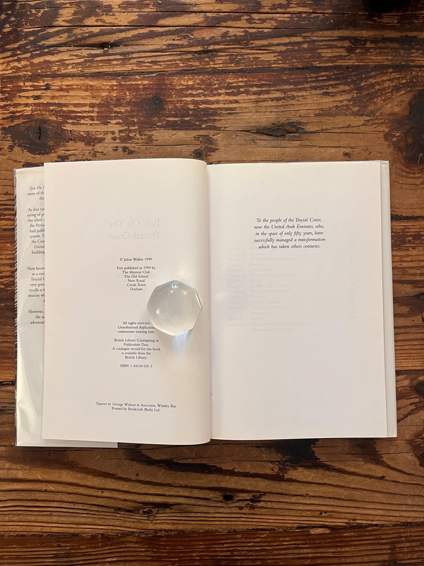 Publisher page of book with the title 'Tyro on the Trucial Coast' by Julian Walker on a wooden surface