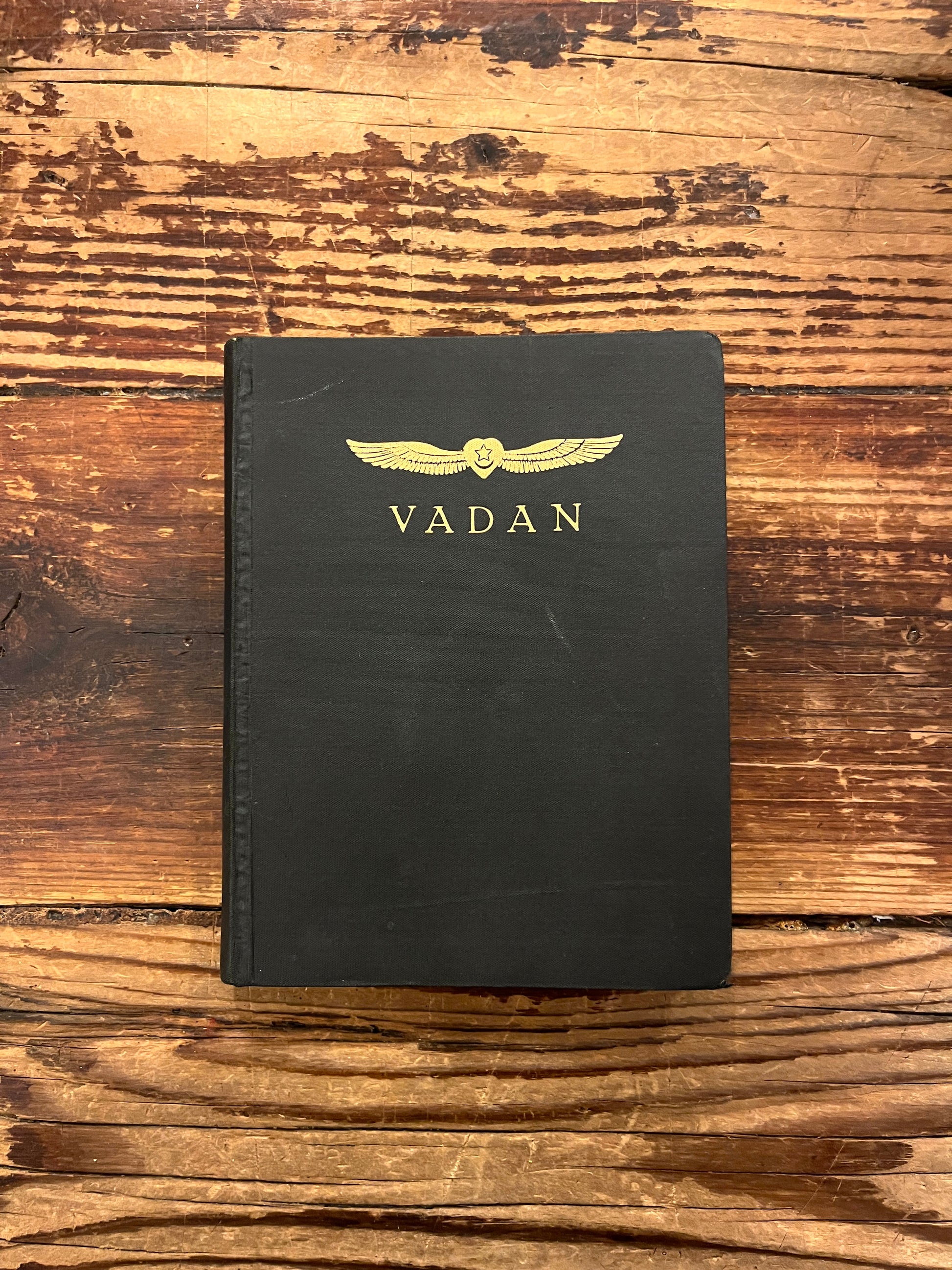 Front cover of book titled 'The divine symphony or Vadan'  by Hazrat Inayat Khan on a wooden surface 