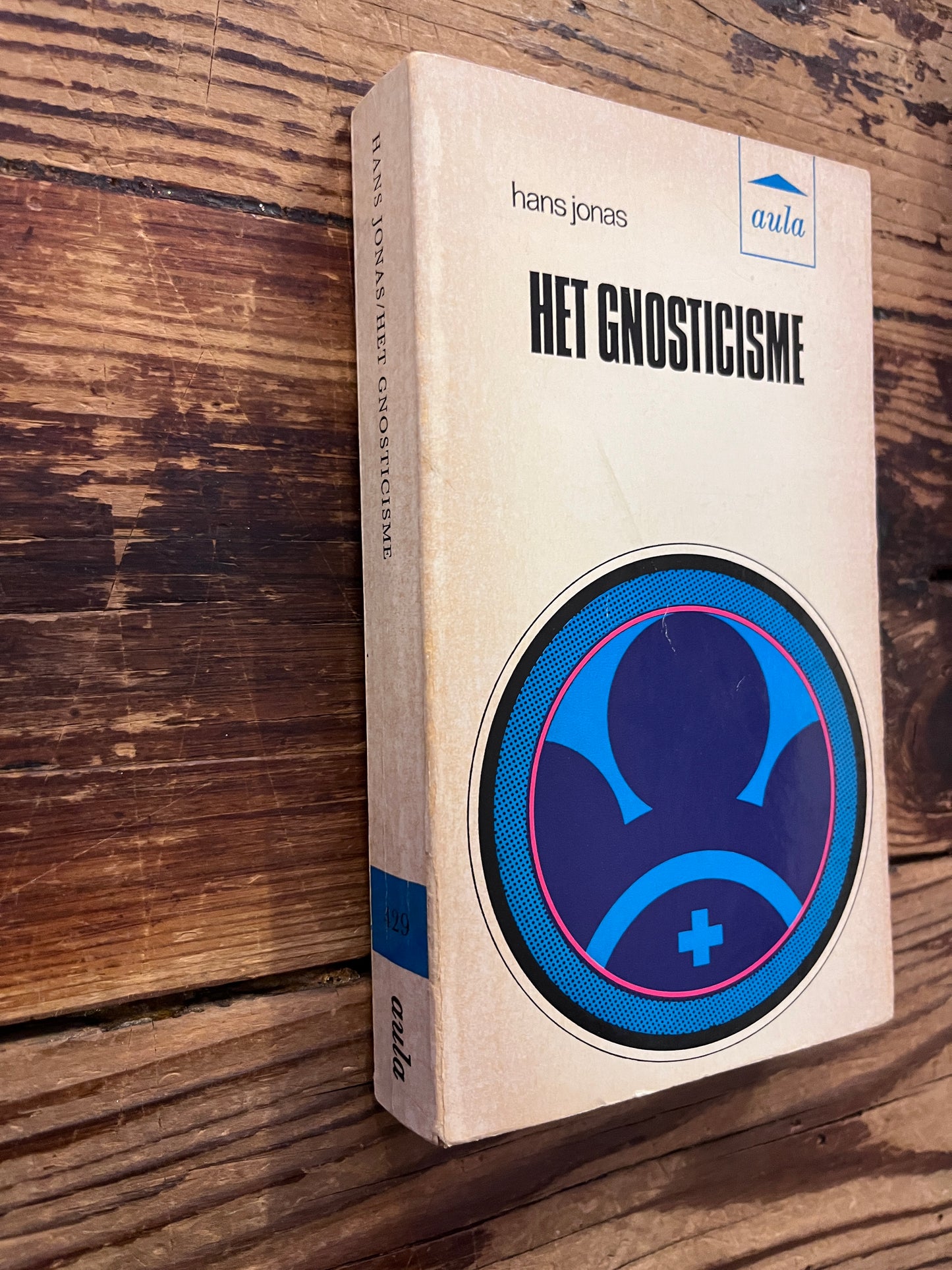 Voorkant en rug van boek met de titel 'Het Gnosticisme' door Hans Jonas op een houten achtergrond 