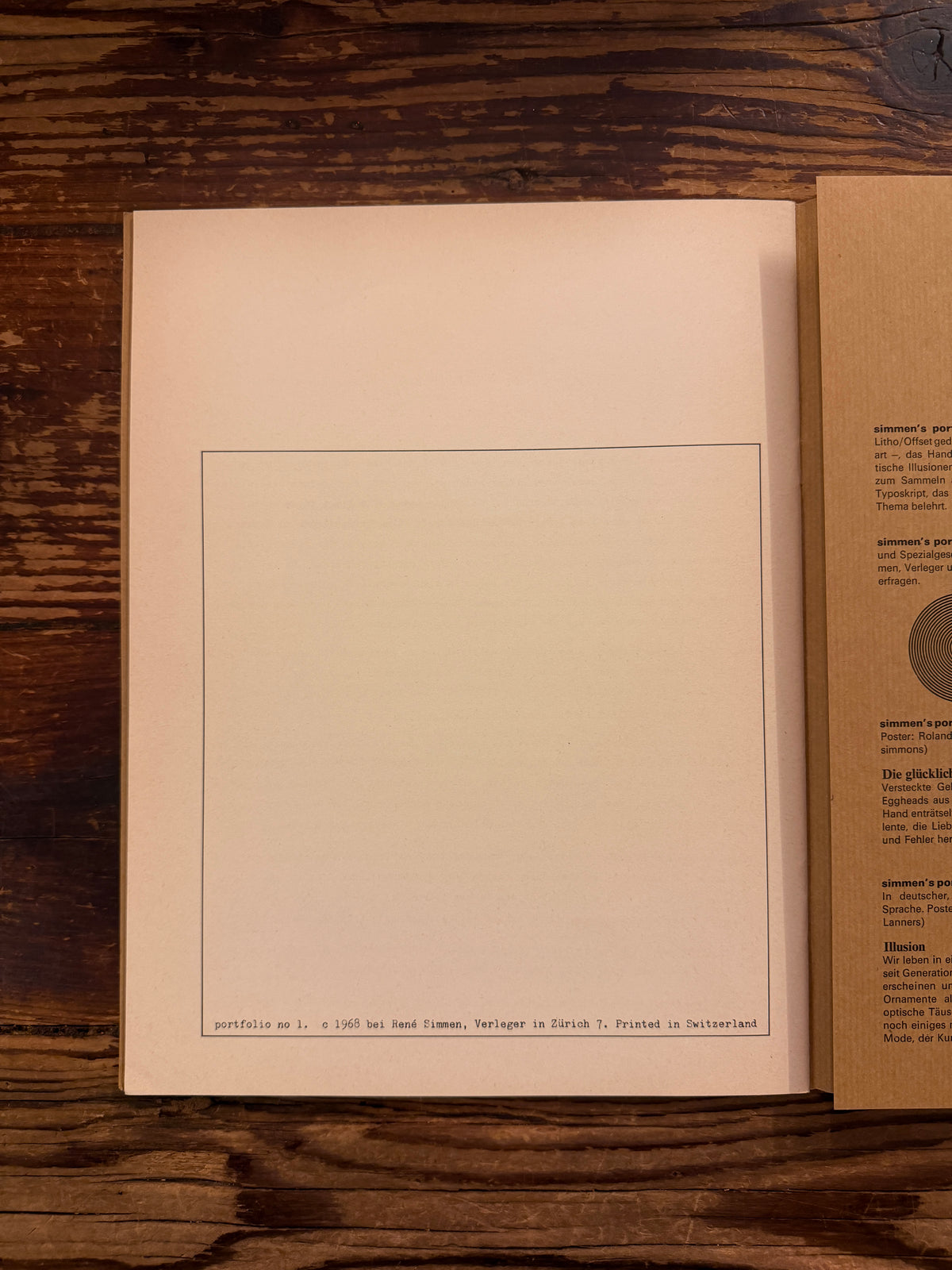 Last page of 'Simmen's Portfolio No. 1: Die glückliche Hand' on a wooden background 