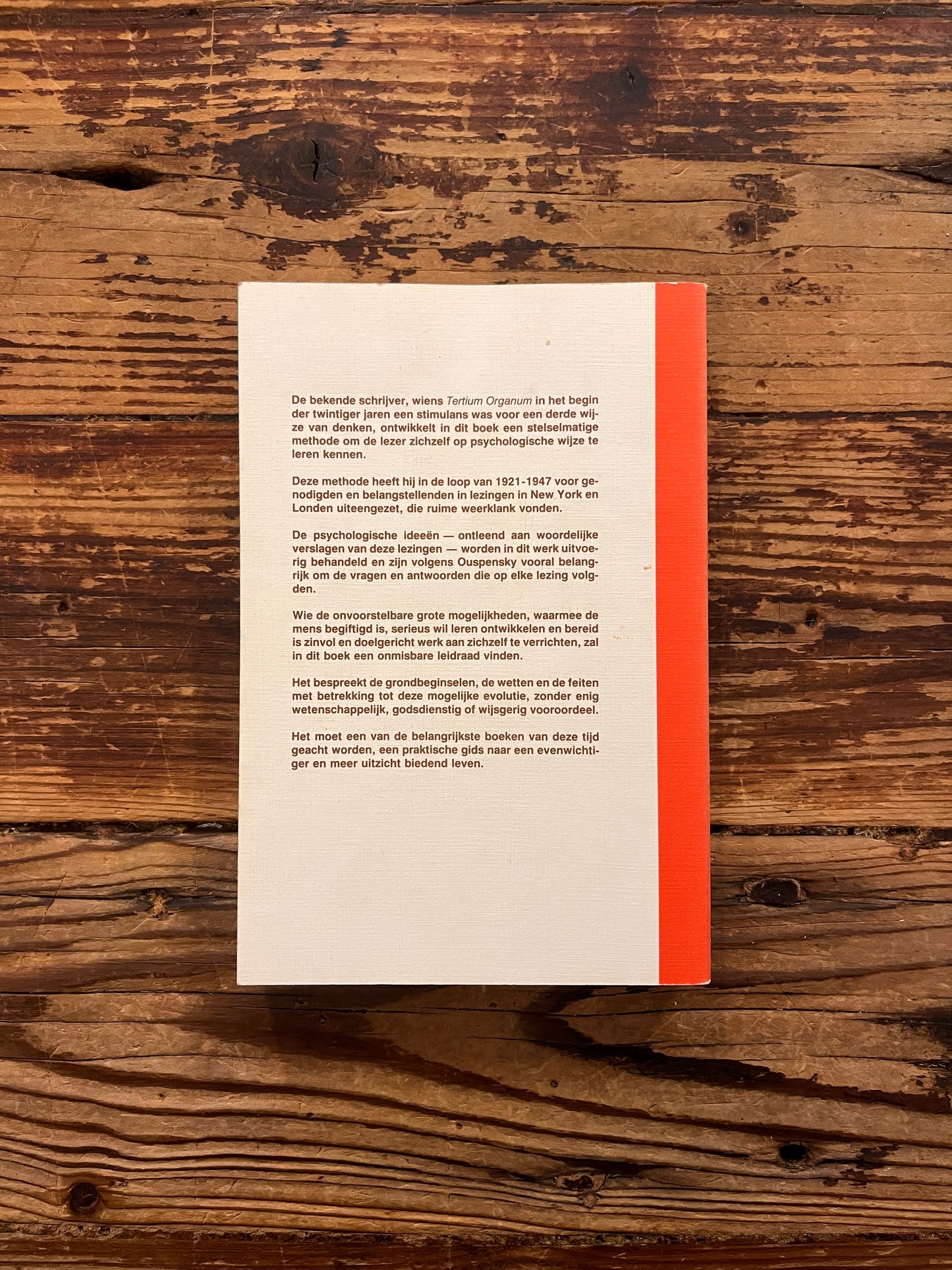 Achterkant van boek met de titel 'de vierde weg door P.D. Ouspensky op een houten achtergrond 