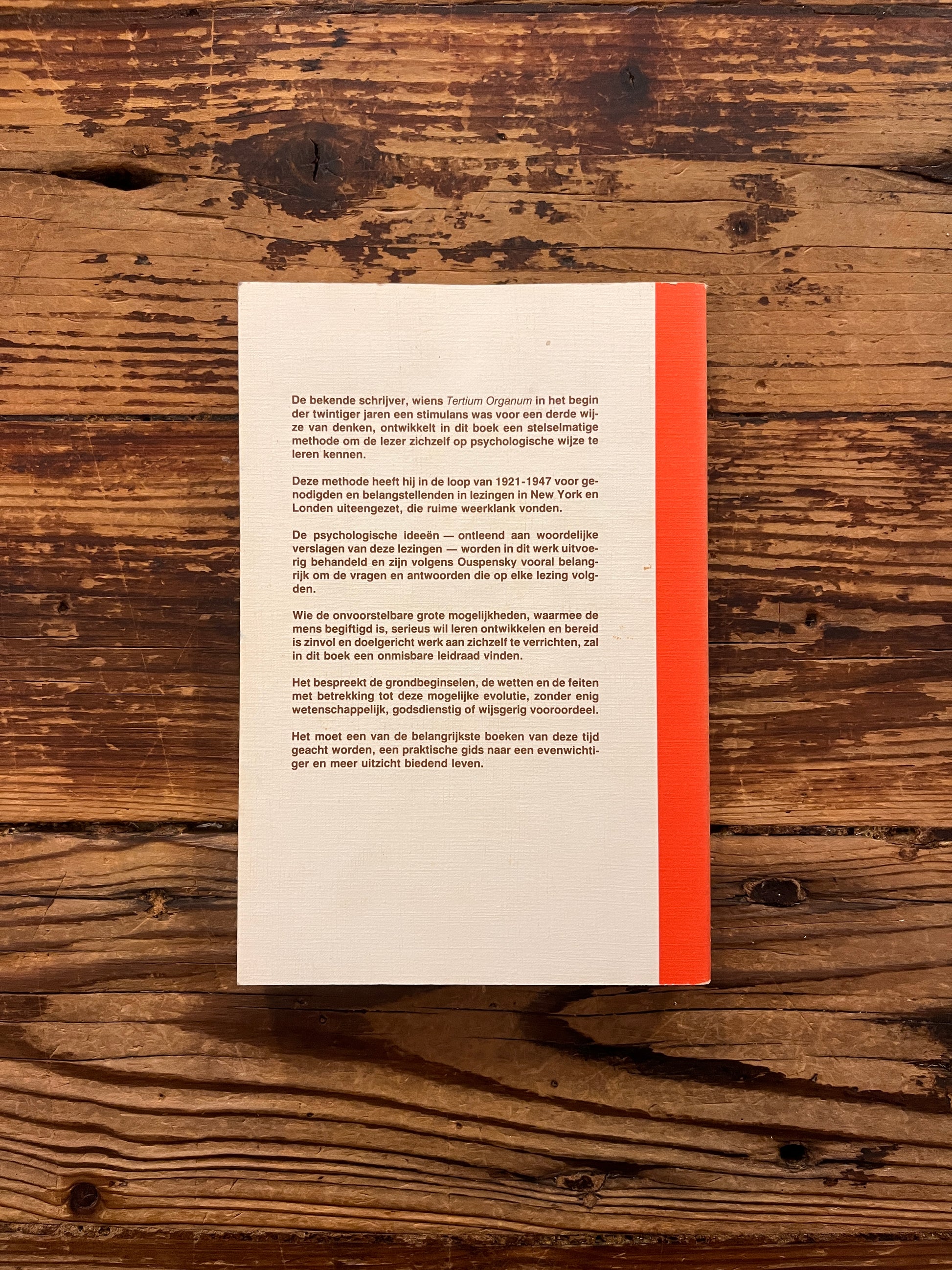 Achterkant van boek met de titel 'de vierde weg door P.D. Ouspensky op een houten achtergrond 