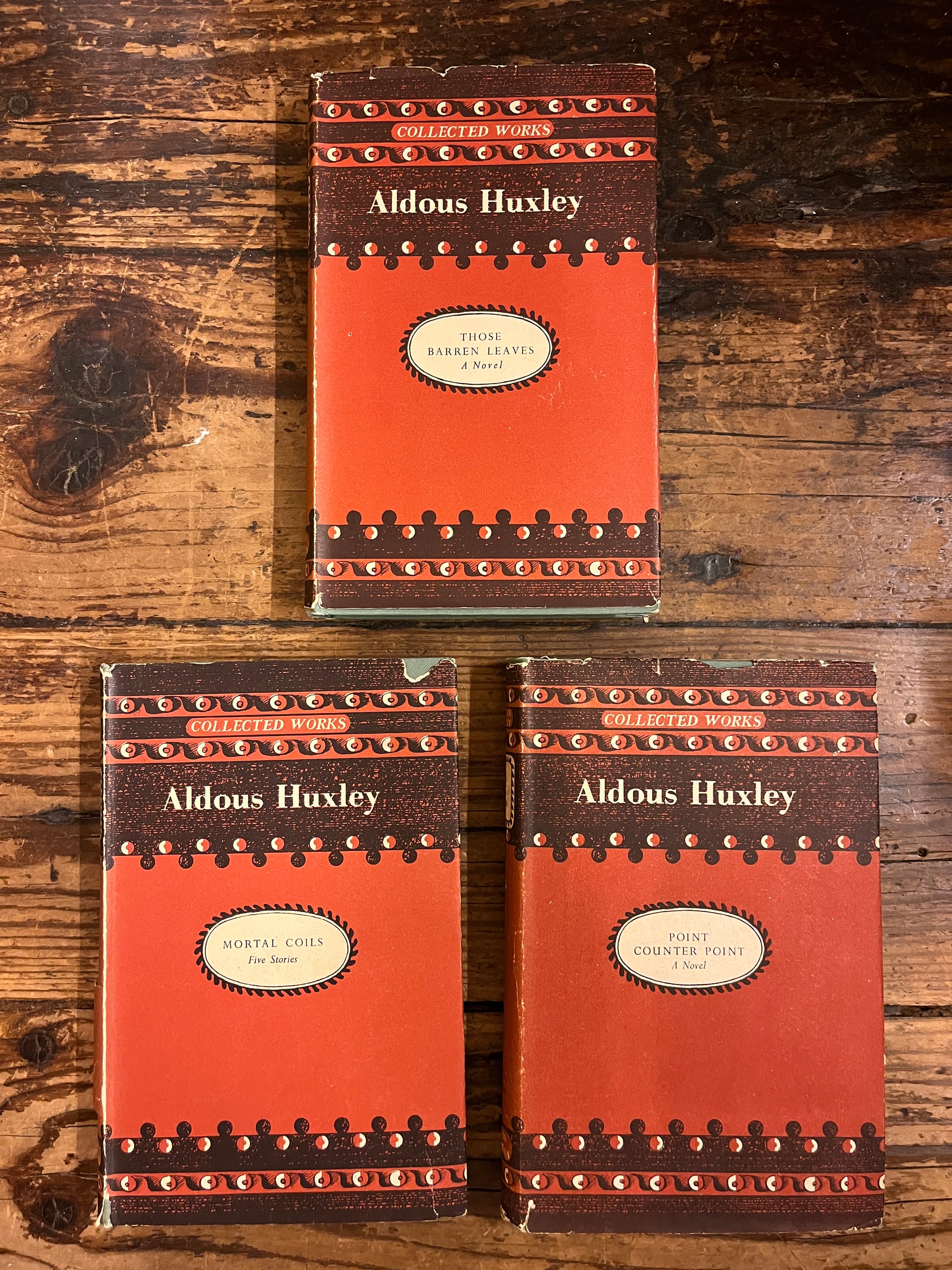 photo of the front cover of 3 books from aldous huxley on a wooden background