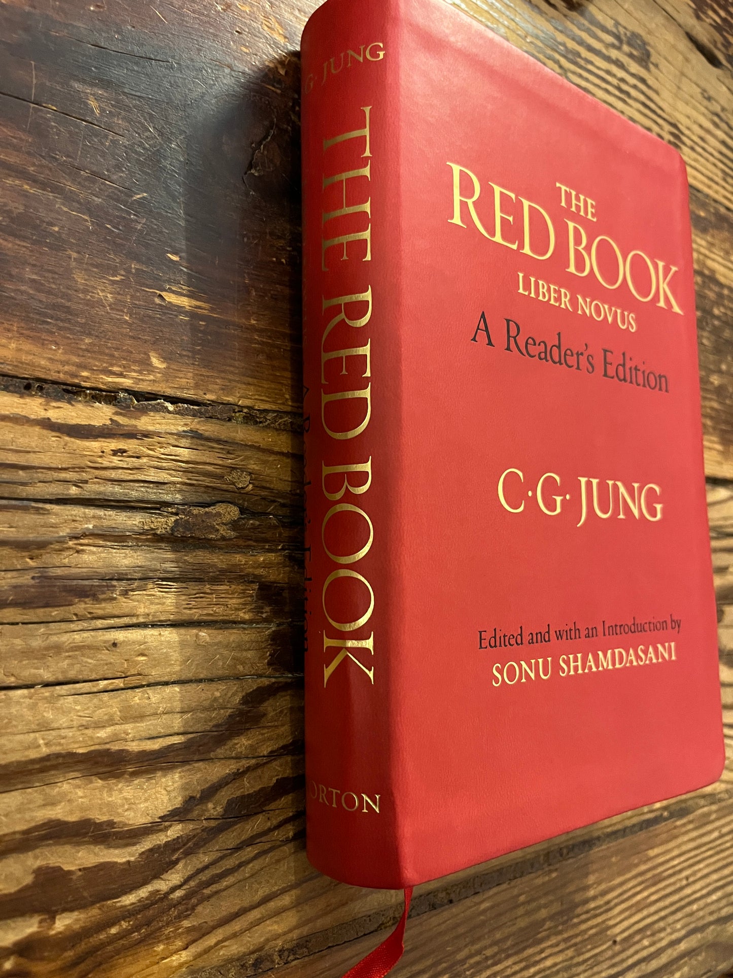 Book titled 'The Red Book' by C.G. Jung on a wooden surface