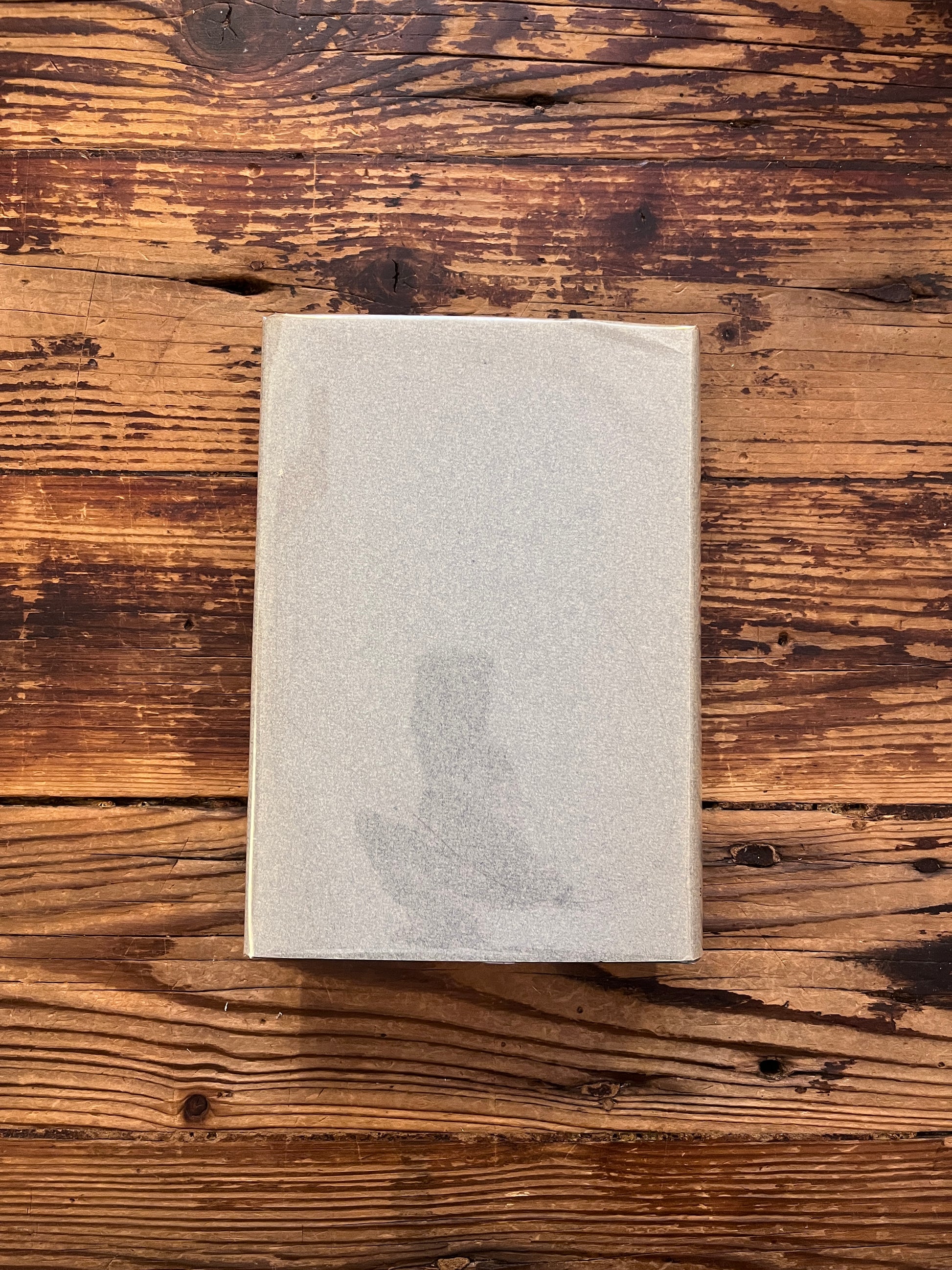 Achterkant van boek met de titel 'op zoek naar het wonderbaarlijke, fragmenten van een onbekende leer' door P. D.  Ouspensky op een houten achter grond 