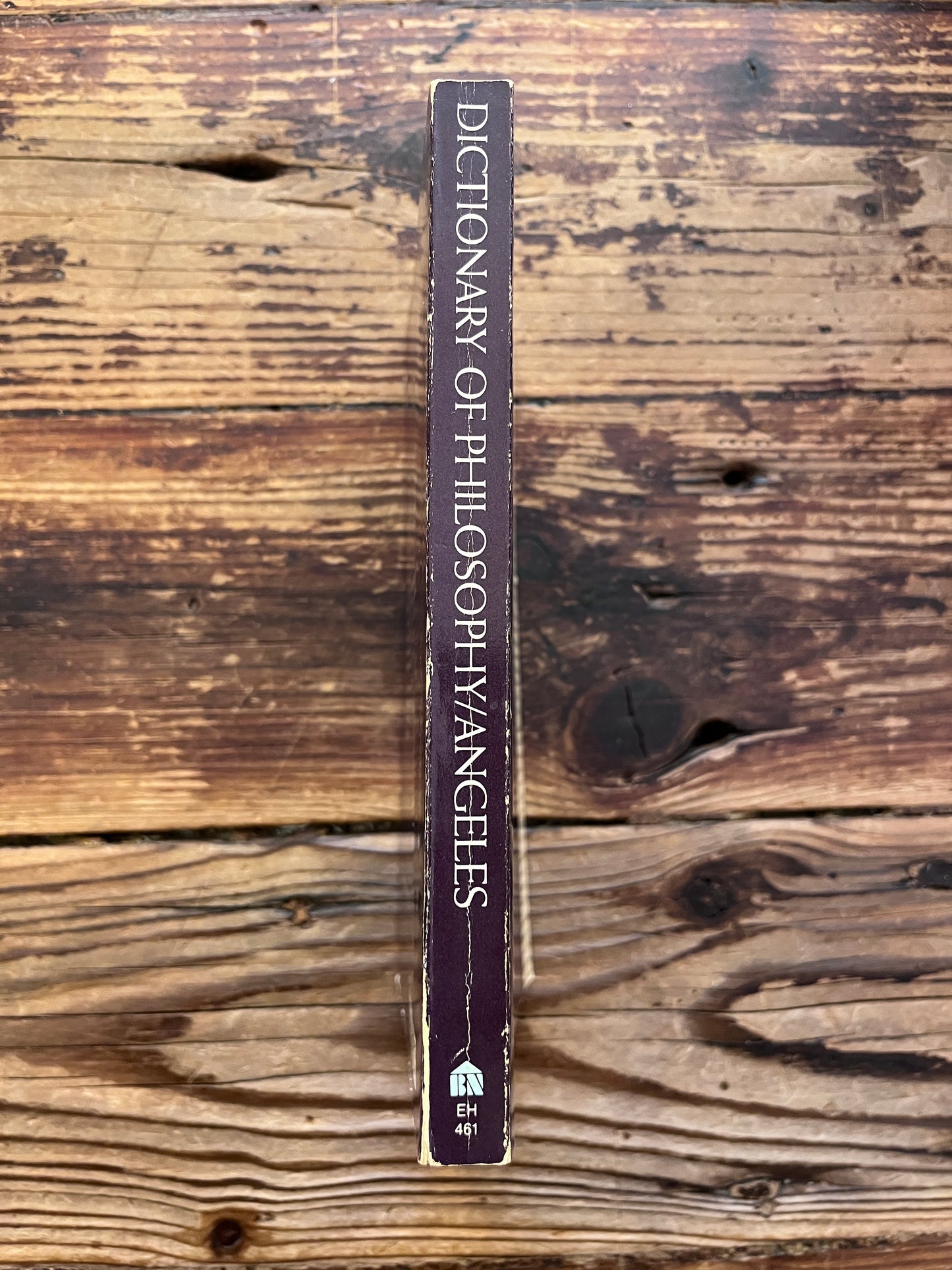 photo of the spine of the ook "Dictionary of philosophy" on a wooden background