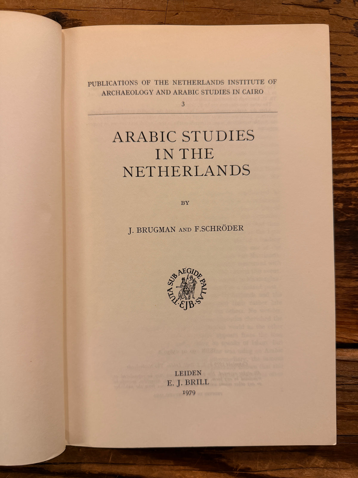 First page of a book titled 'Arabic Studies in the Netherlands' by J. Brugman en F. Schröder, lying on a wooden surface