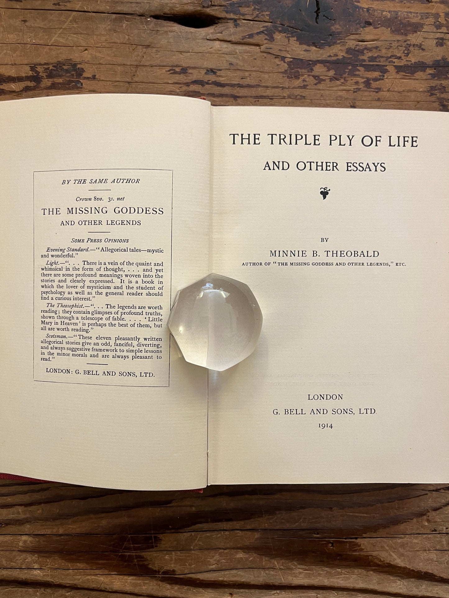 Open book titled 'The Triple Ply of Life' by Minnie E. Theobald on a wooden surface