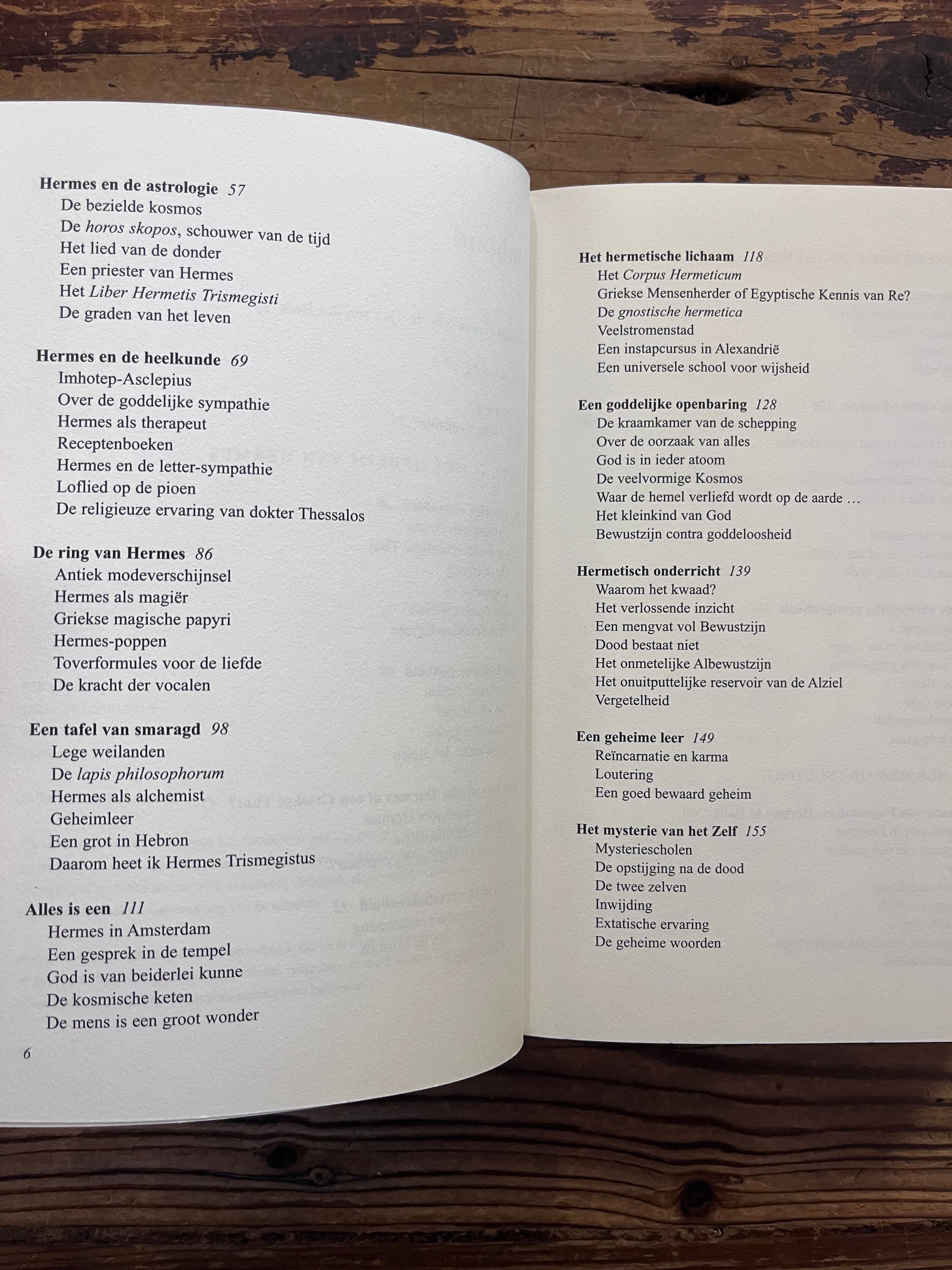 Open boek met de titel 'de Hermetische Schakel' door Jacob Slavenburg op een houten achtergrond 