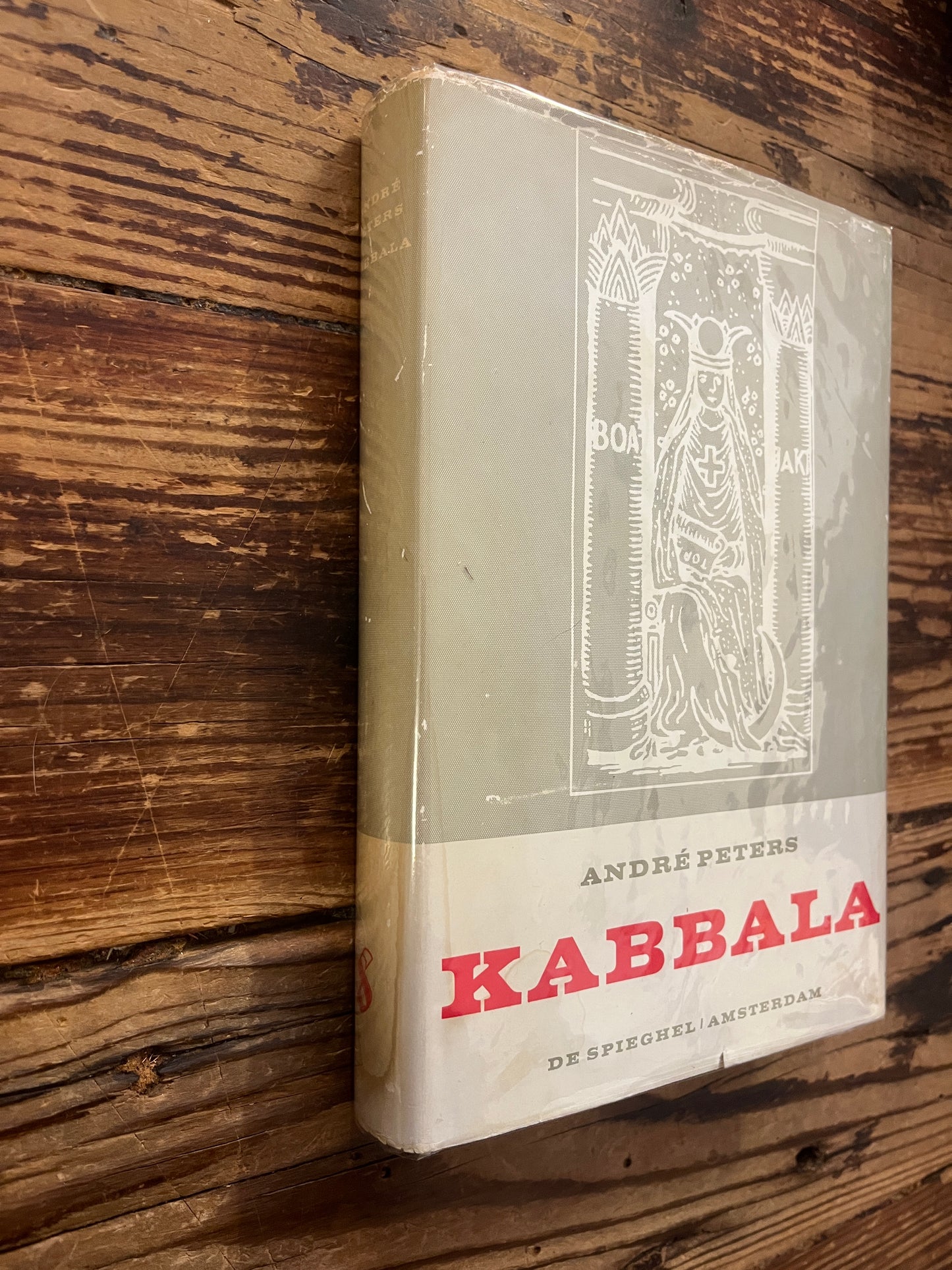 Boek met de titel 'Kabbala' door Andre Peters op een houten achtergrond