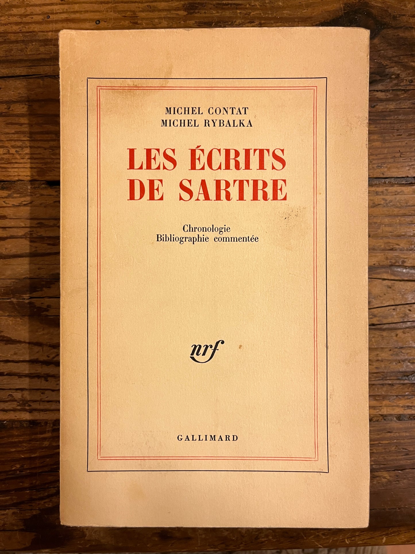 couverture du livre "les ecrits de sartre" sur fond de bois