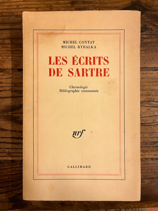 couverture du livre "les ecrits de sartre" sur fond de bois