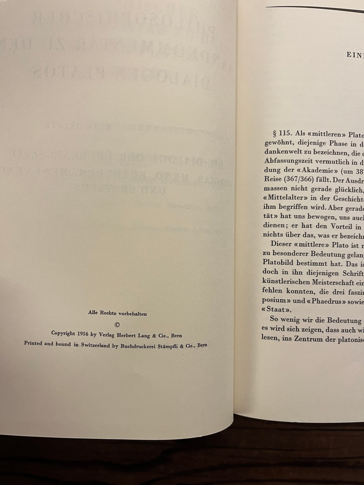 Open book titled 'Philosophischer Handkommentar zu den Dialogen Platos' by H. Gauss on a wooden surface 