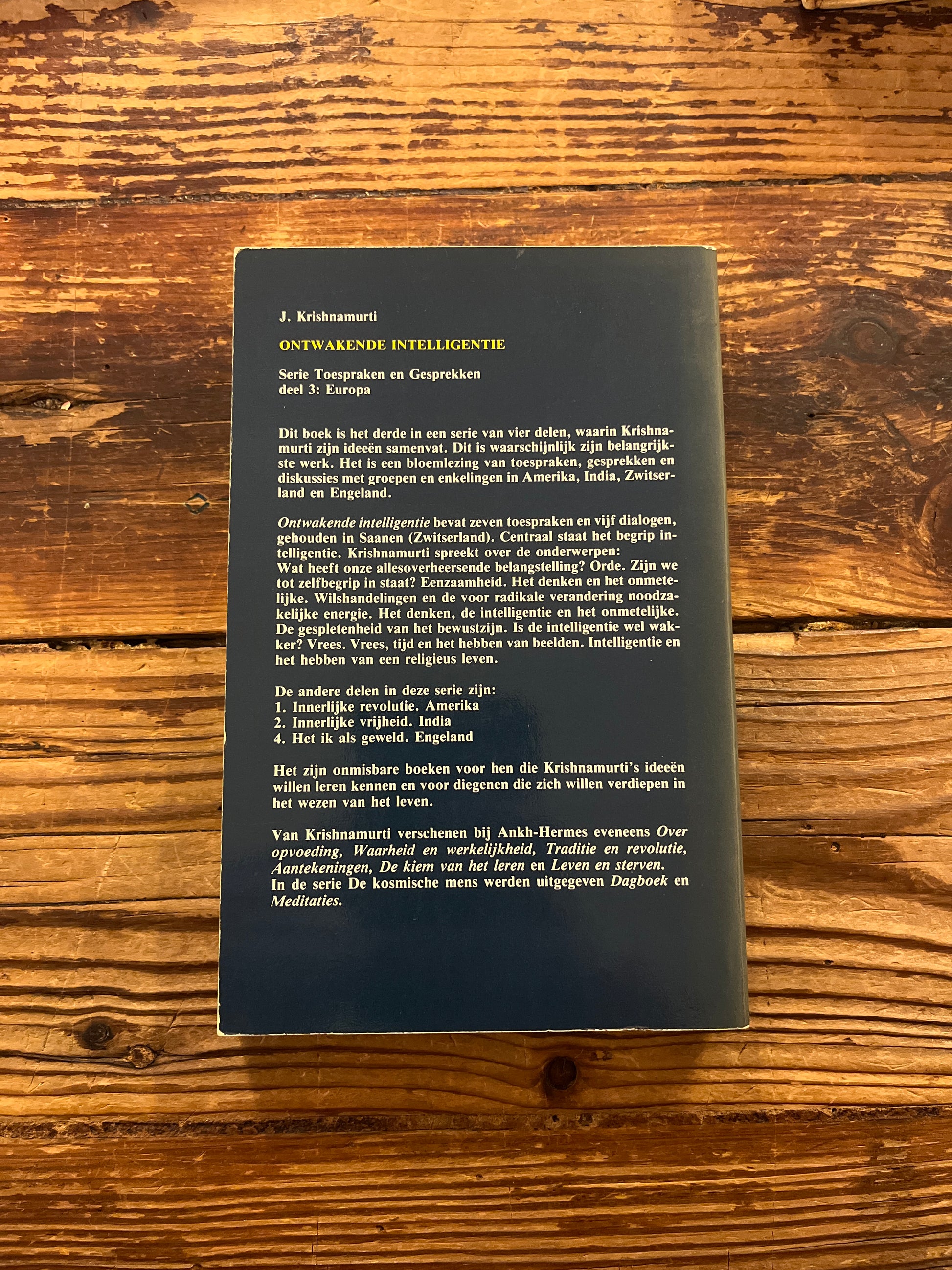Achterkant van boek met de titel 'ontwakende intelligentie' door Krishnamurti op een houten achtergrond 