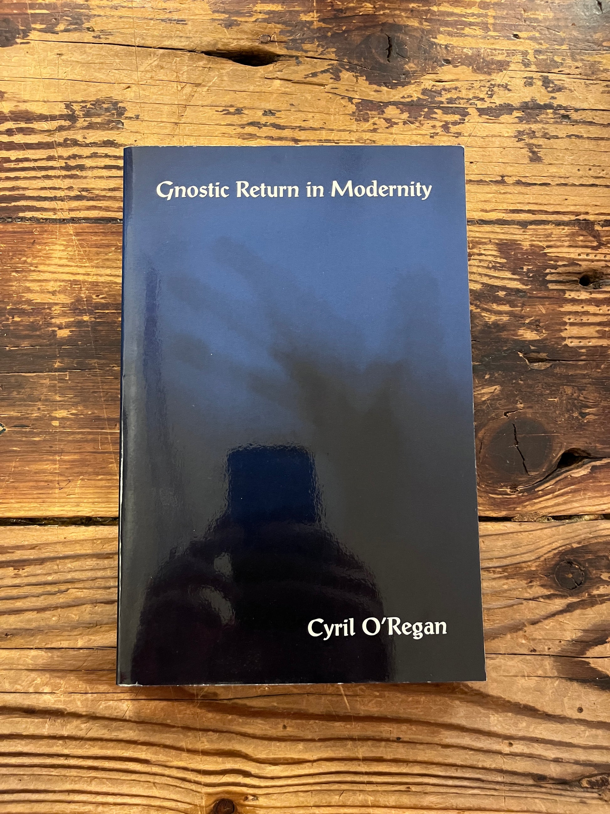 cover of the book "gnostic return in modernity" on wooden background