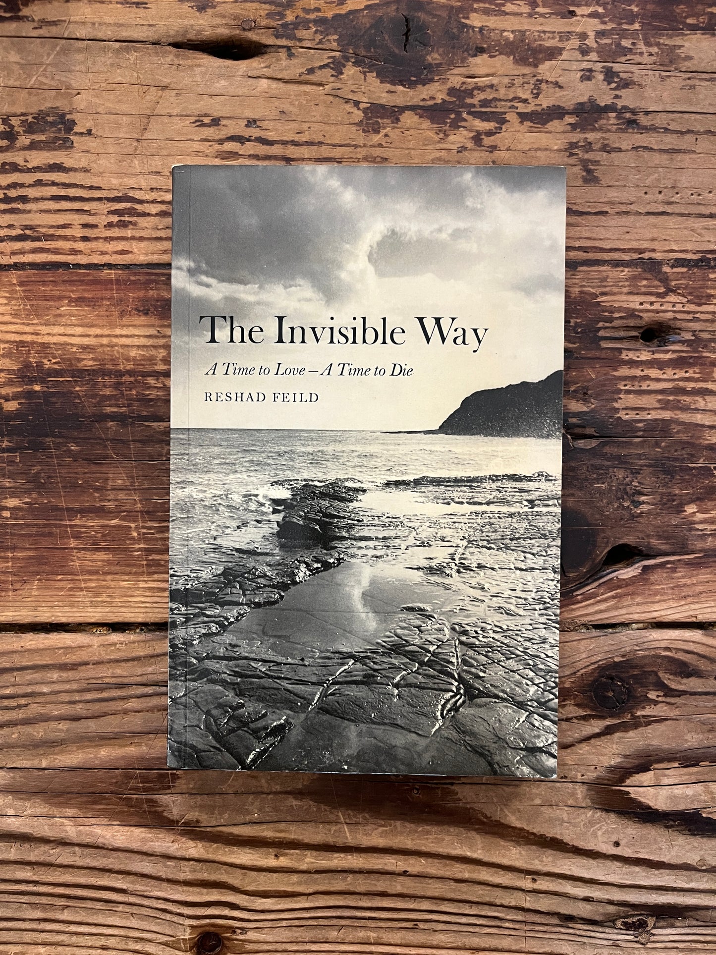 Front cover of book witht he title 'the invisible way' by Reshad Feild on a wooden surface 