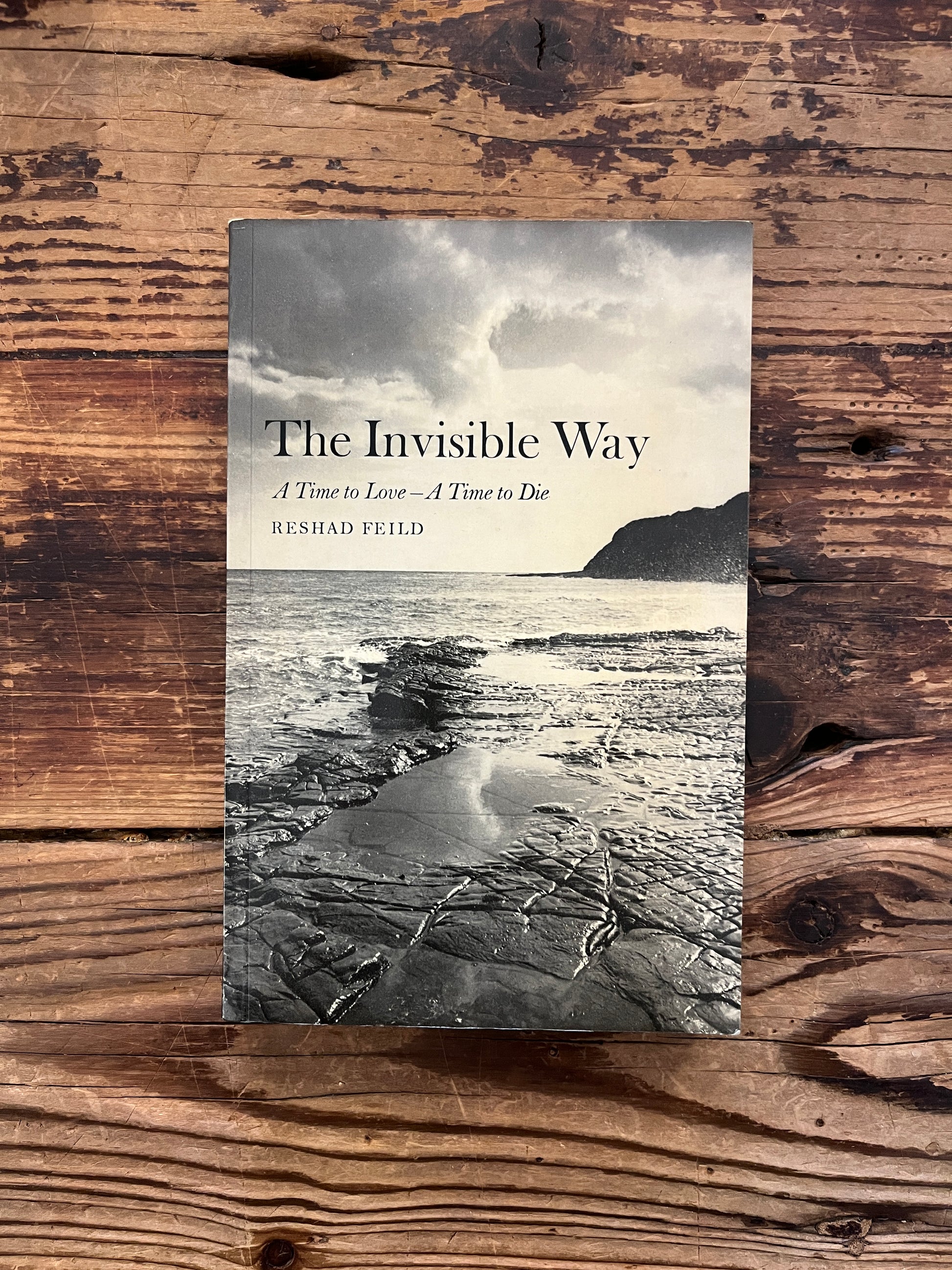 Front cover of book witht he title 'the invisible way' by Reshad Feild on a wooden surface 