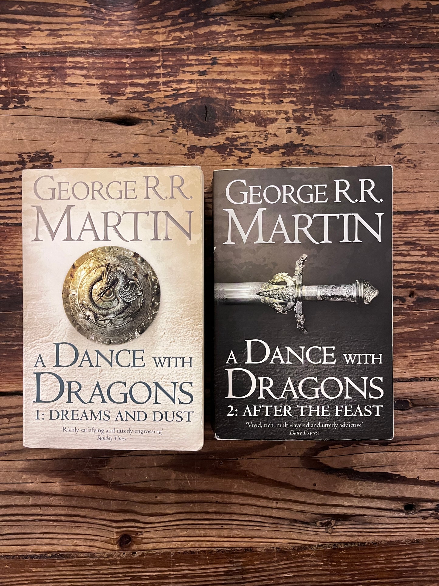 Two books titled 'A Dance with Dragons' by George R.R. Martin on a wooden surface.