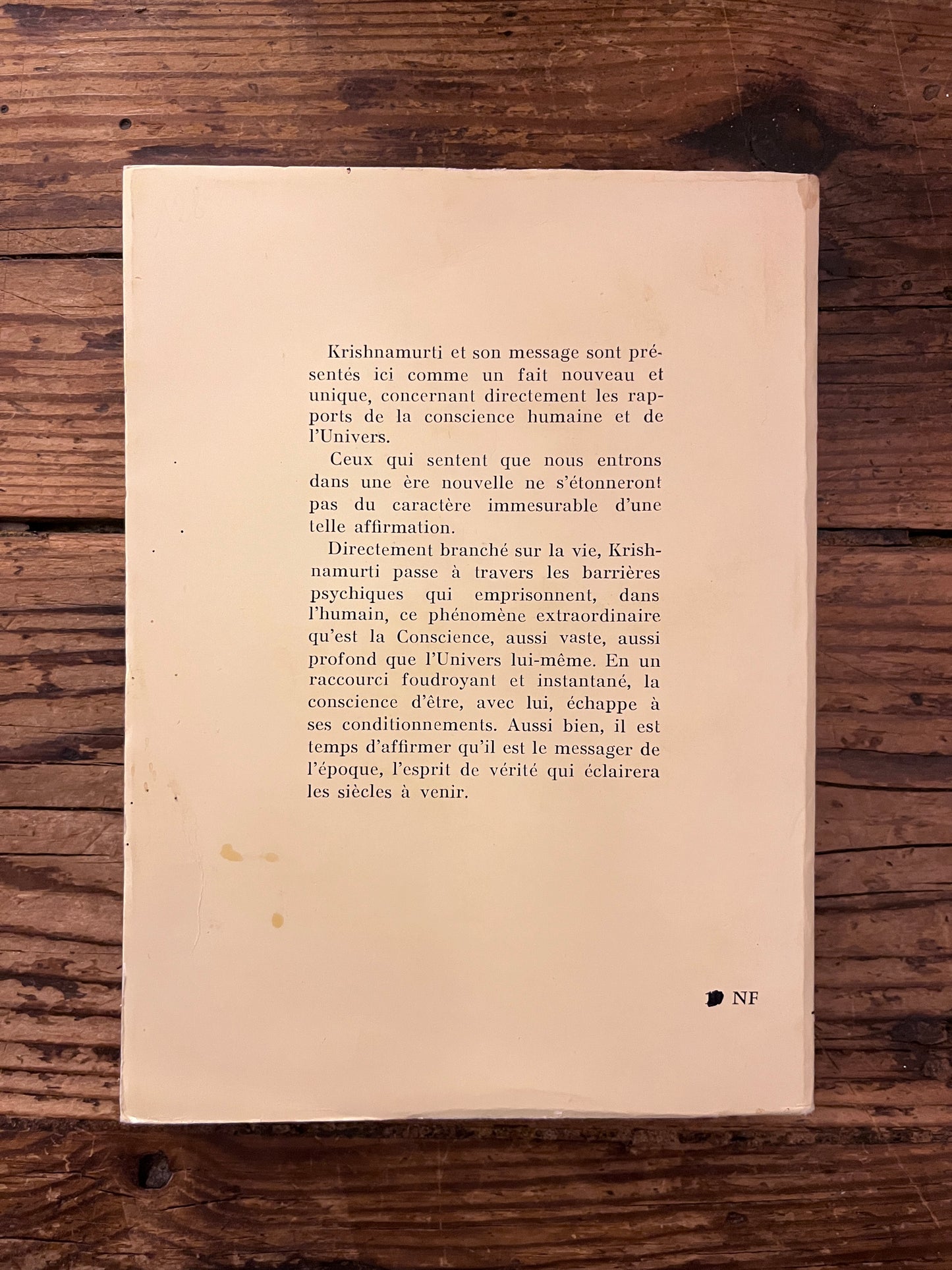 dos du livre" Krishnamurti et l' unite humaine" sur fond de bois