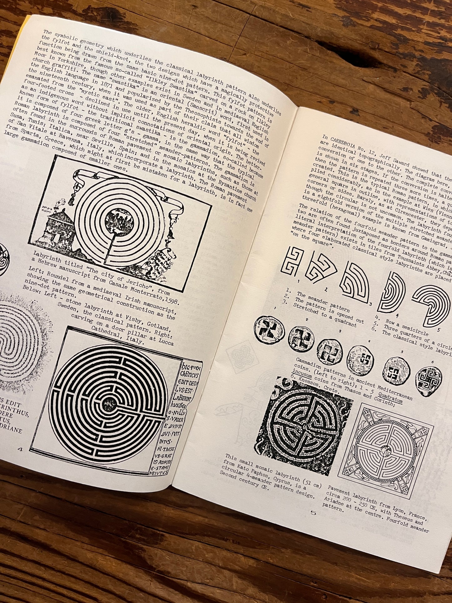 Open booklet with the title 'Labyrinths, their geomancy and symbolism' by Nigel Pennick on a wooden surface 