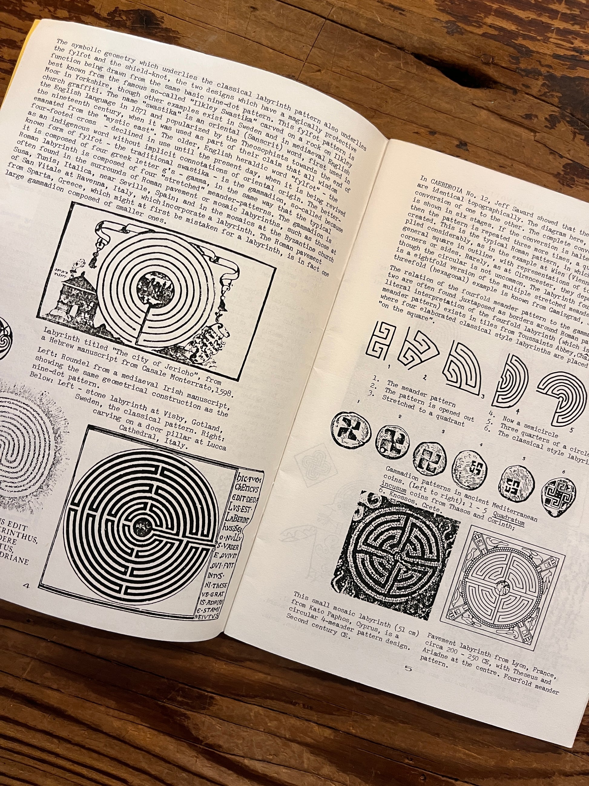 Open booklet with the title 'Labyrinths, their geomancy and symbolism' by Nigel Pennick on a wooden surface 