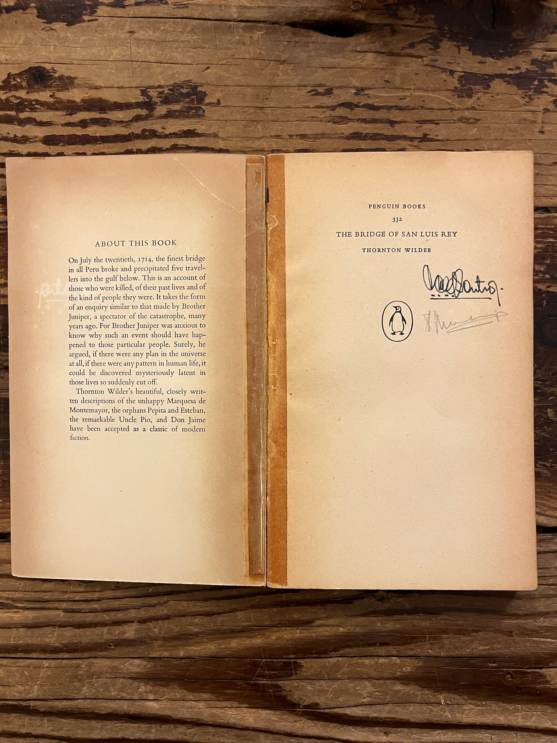 Open book titled 'The Bridge of San Luis Rey' by Thornton Wilder on a wooden surface