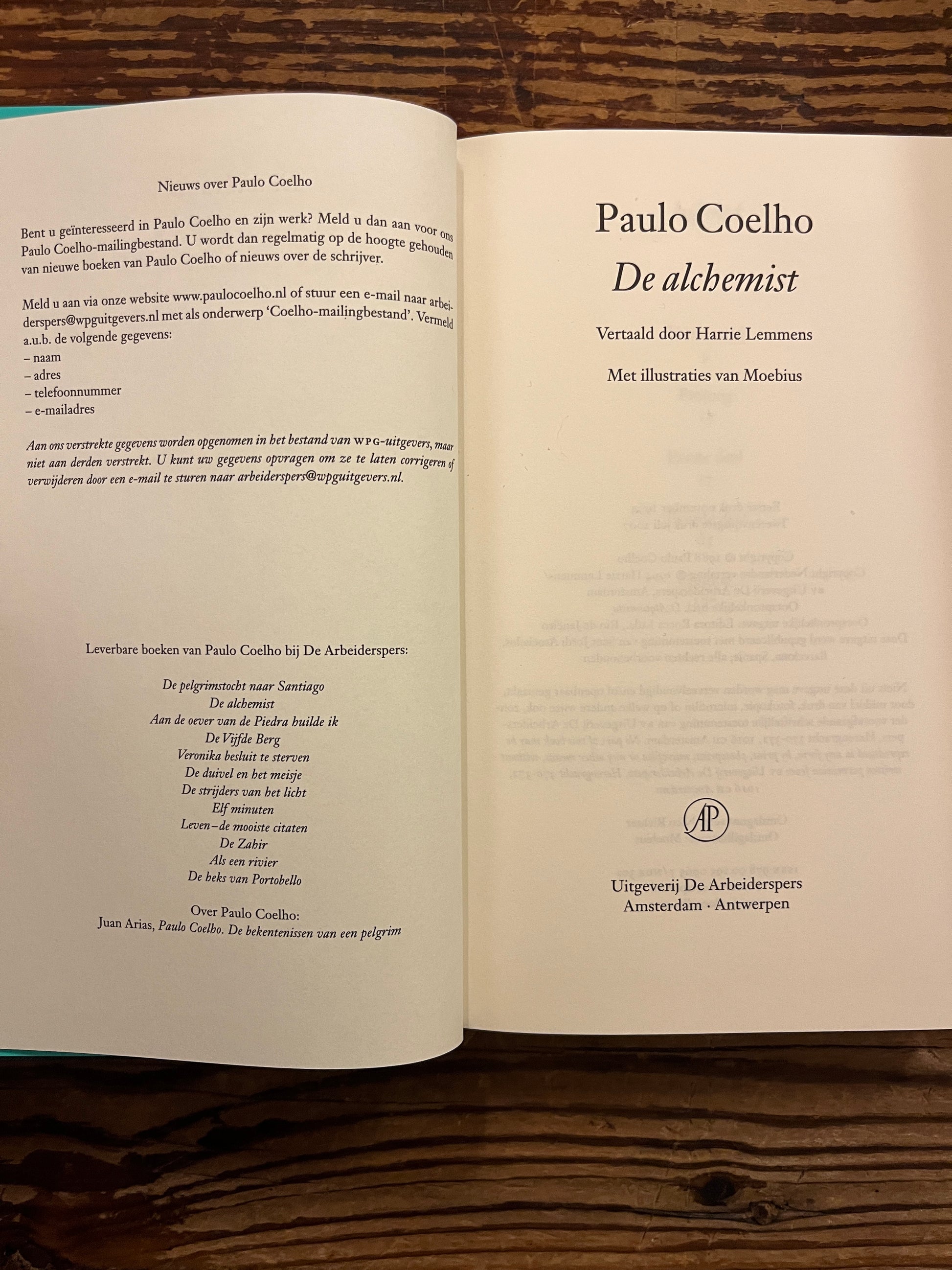 Open boek 'De Alchemist' door Paulo Coelho op houten achtergrond 
