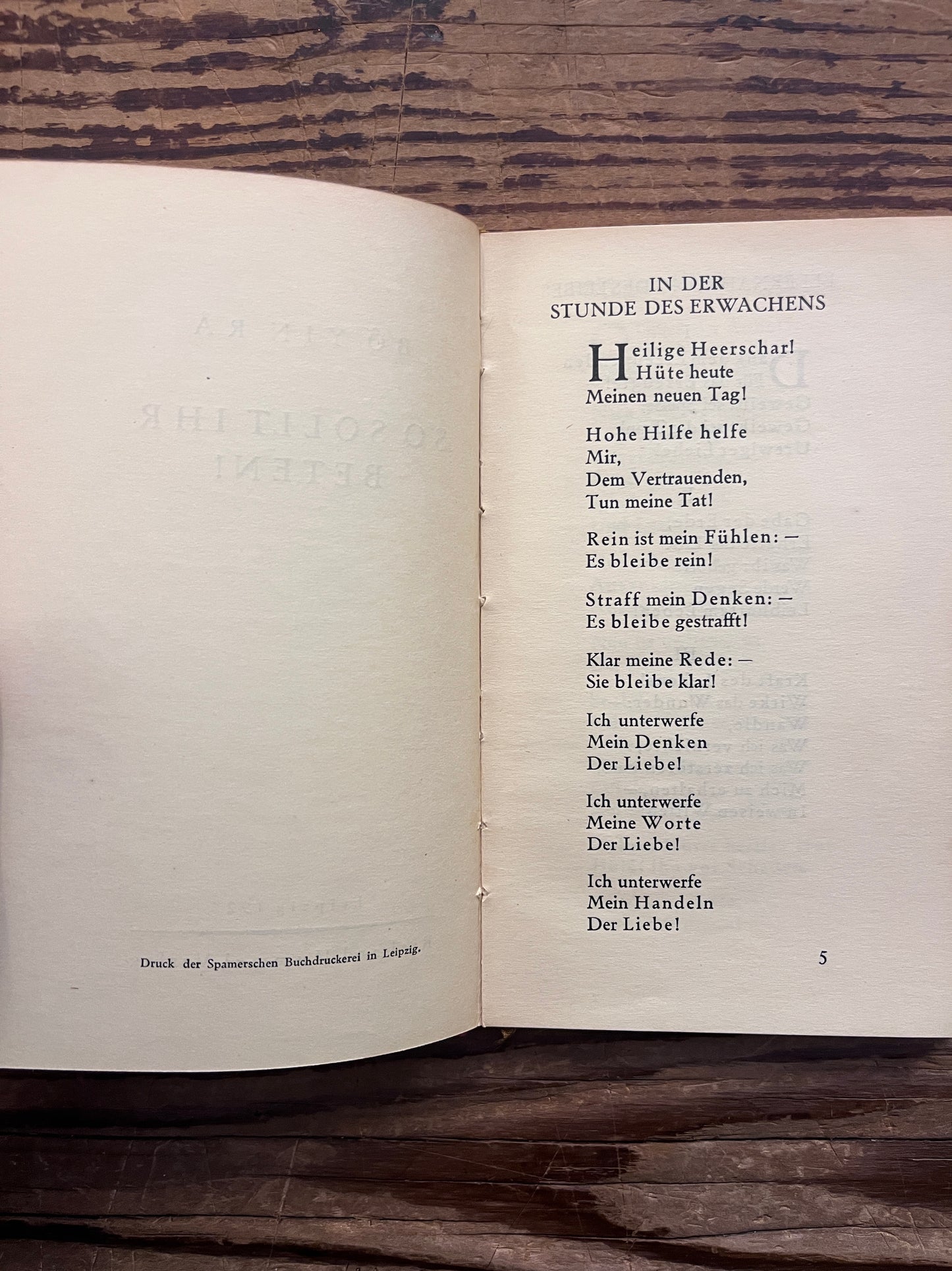 Open booklet with the title 'So Sollt Ihr Beten' by Bo Yin Ra on a wooden surface 