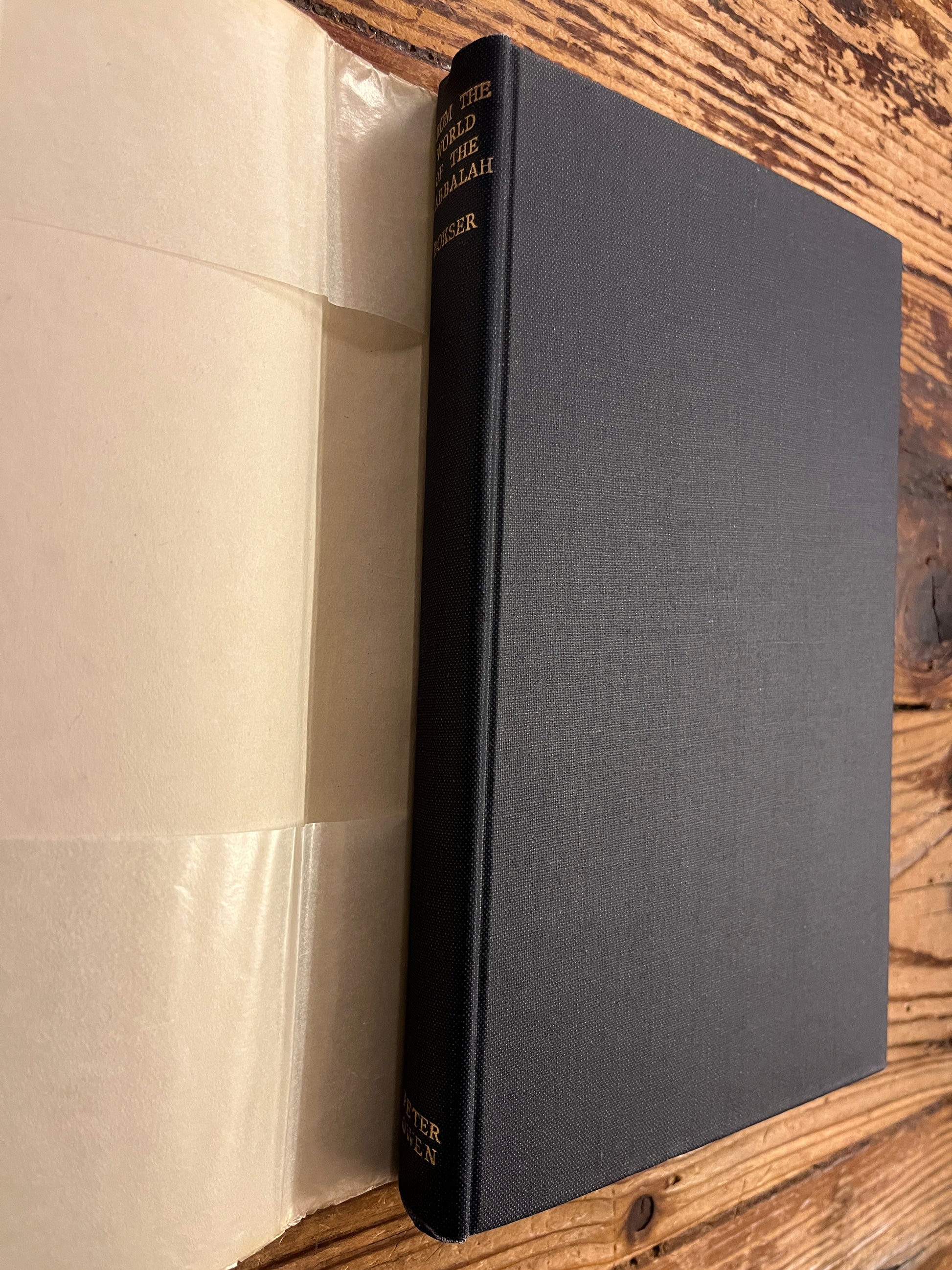Black cloth book without dust jacket of  book titled 'From the World of the Cabbalah' on a wooden surface