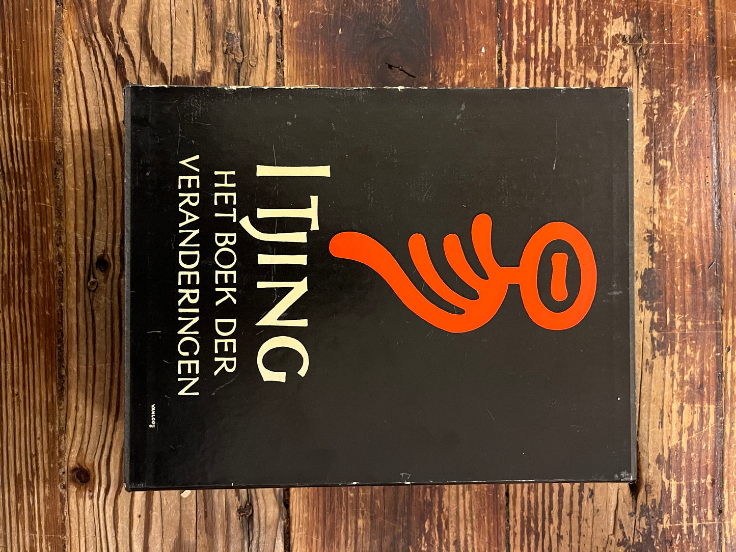 Casette met twee boeken met de titel 'I Tjing: Het Boek Der Veranderingen' op een houten achtergrond